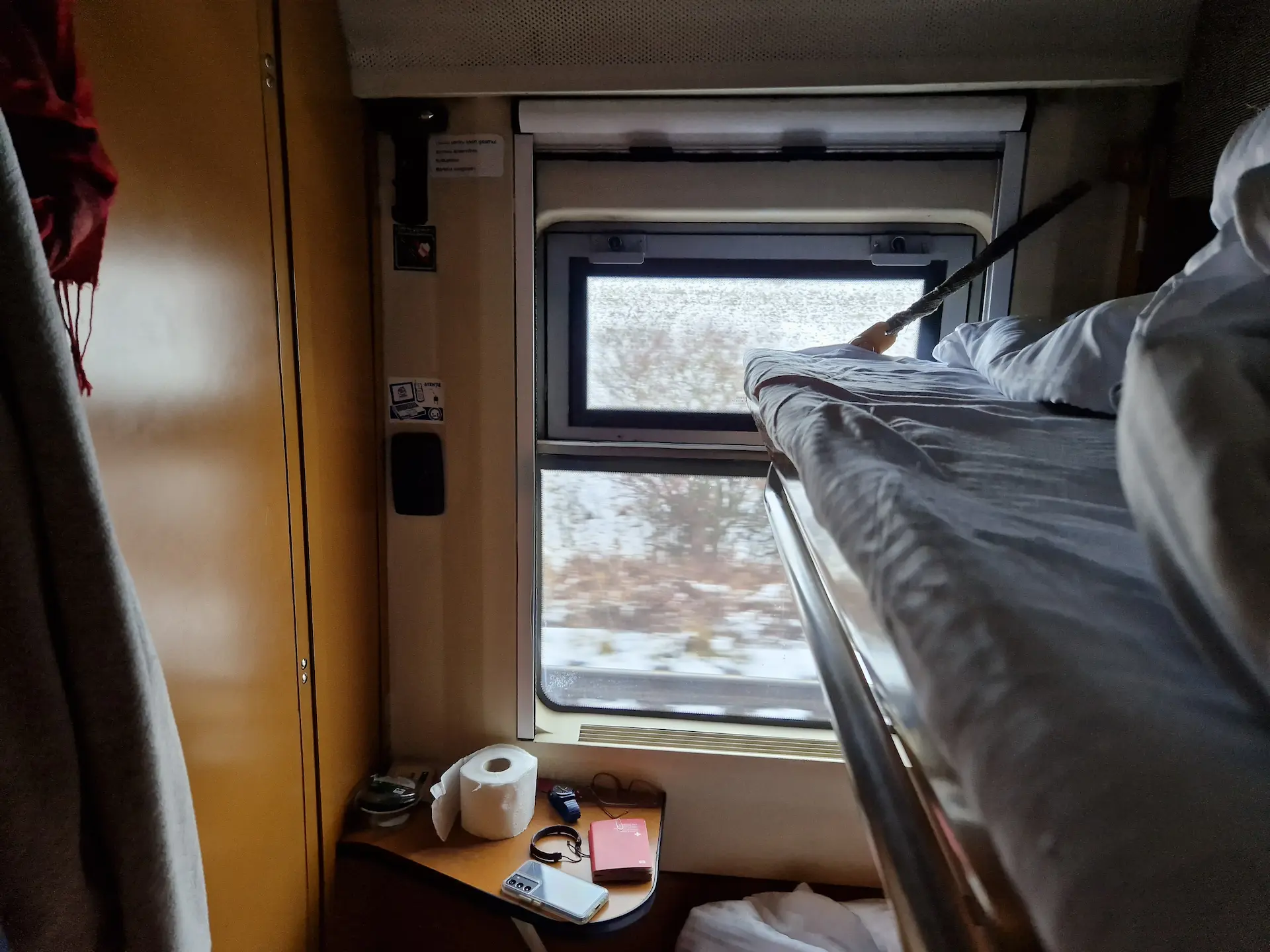 Cabine de train : deux couchettes sur la droite, la salle de bain sur la gauche, la fenêtre en face