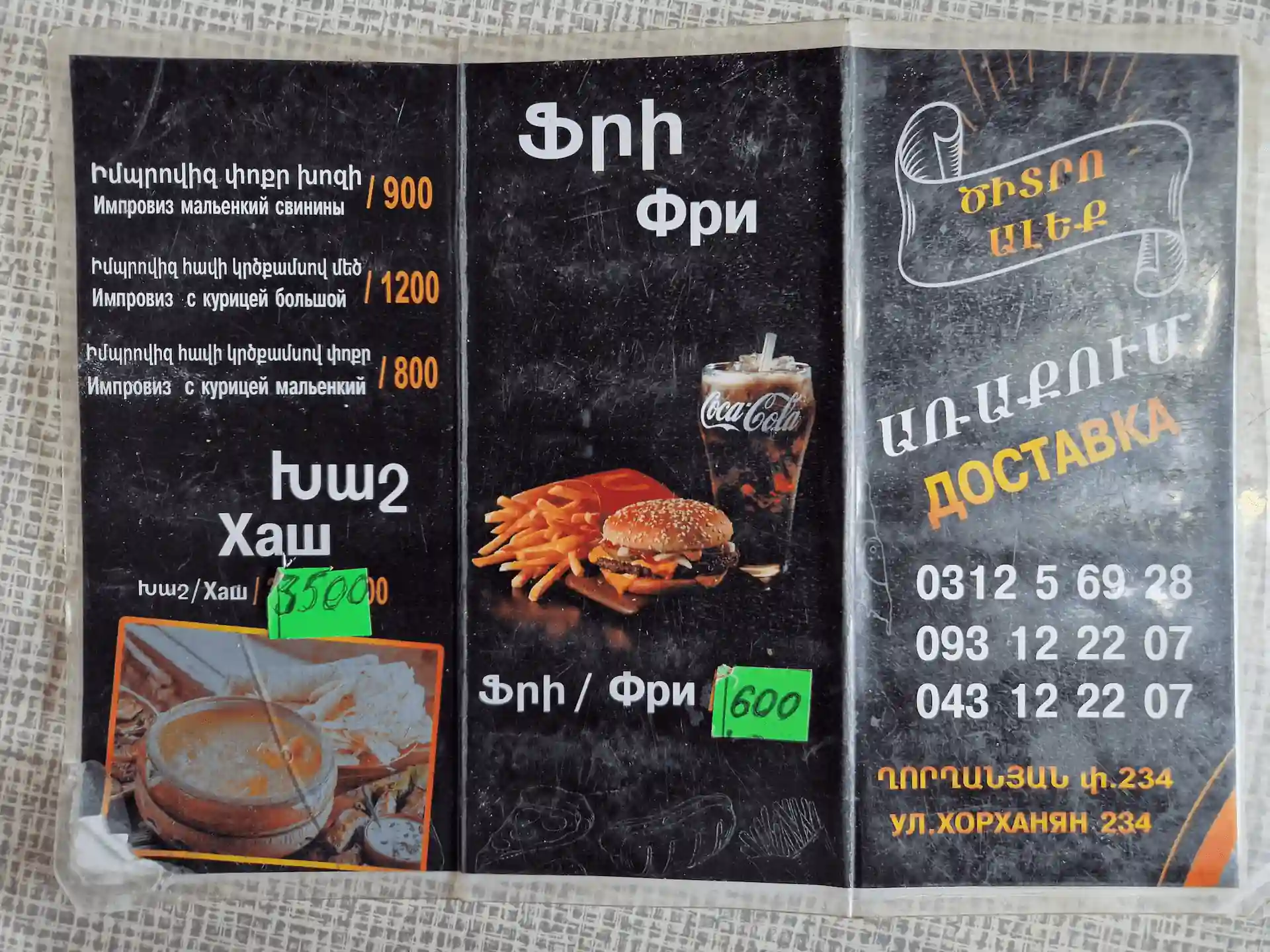 Menu du restaurant en russe et arménien uniquement, on voit une photo de soupe et une photo de hamburger.