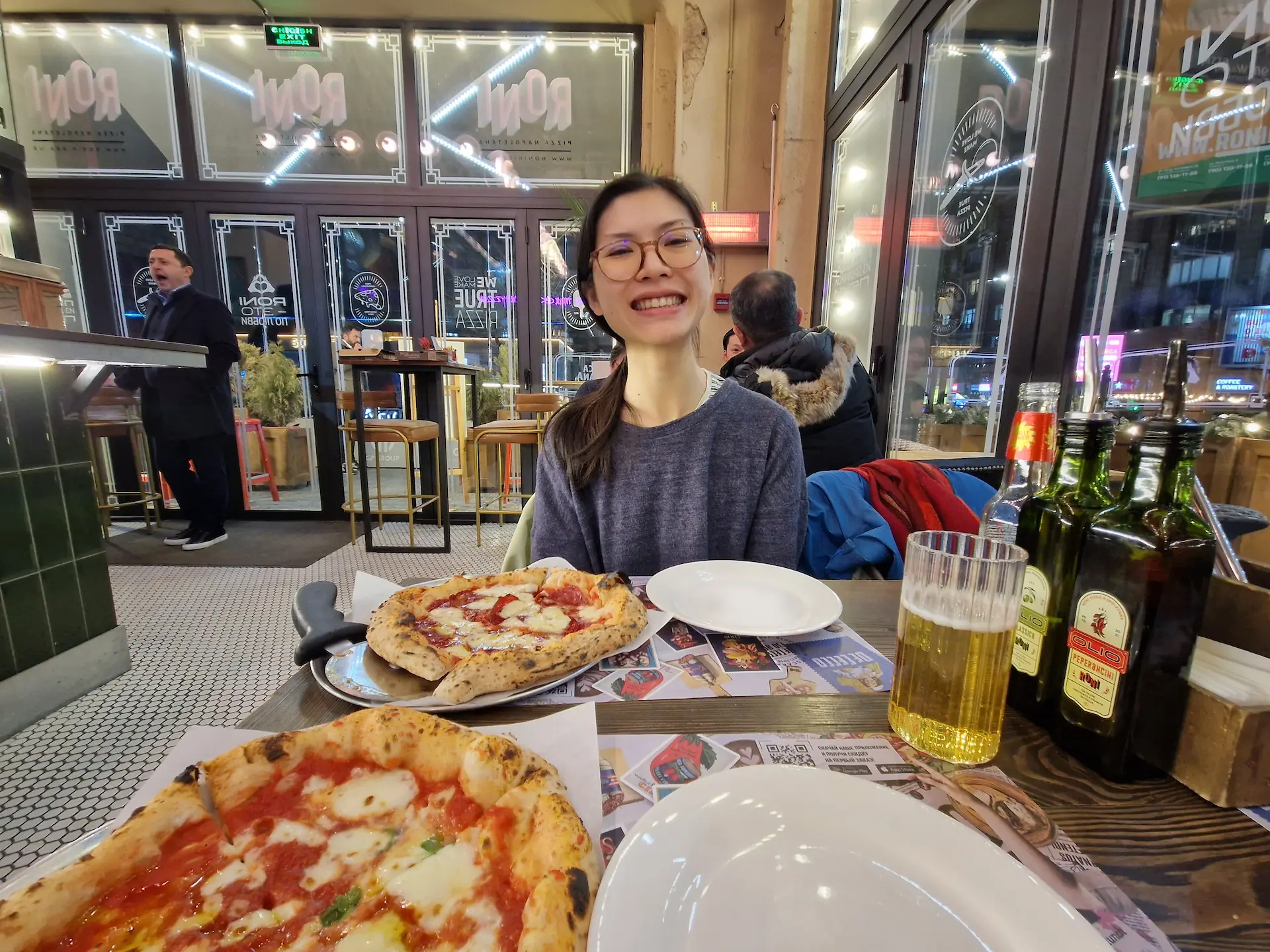 Clara attablée devant deux petites pizzas napolitaines