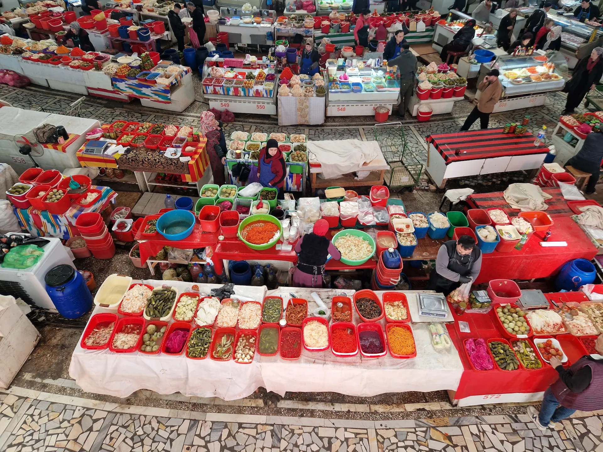 Section koryo-saram : des bacs en plastique rouge et des salades et légumes fermentés de toutes les couleurs