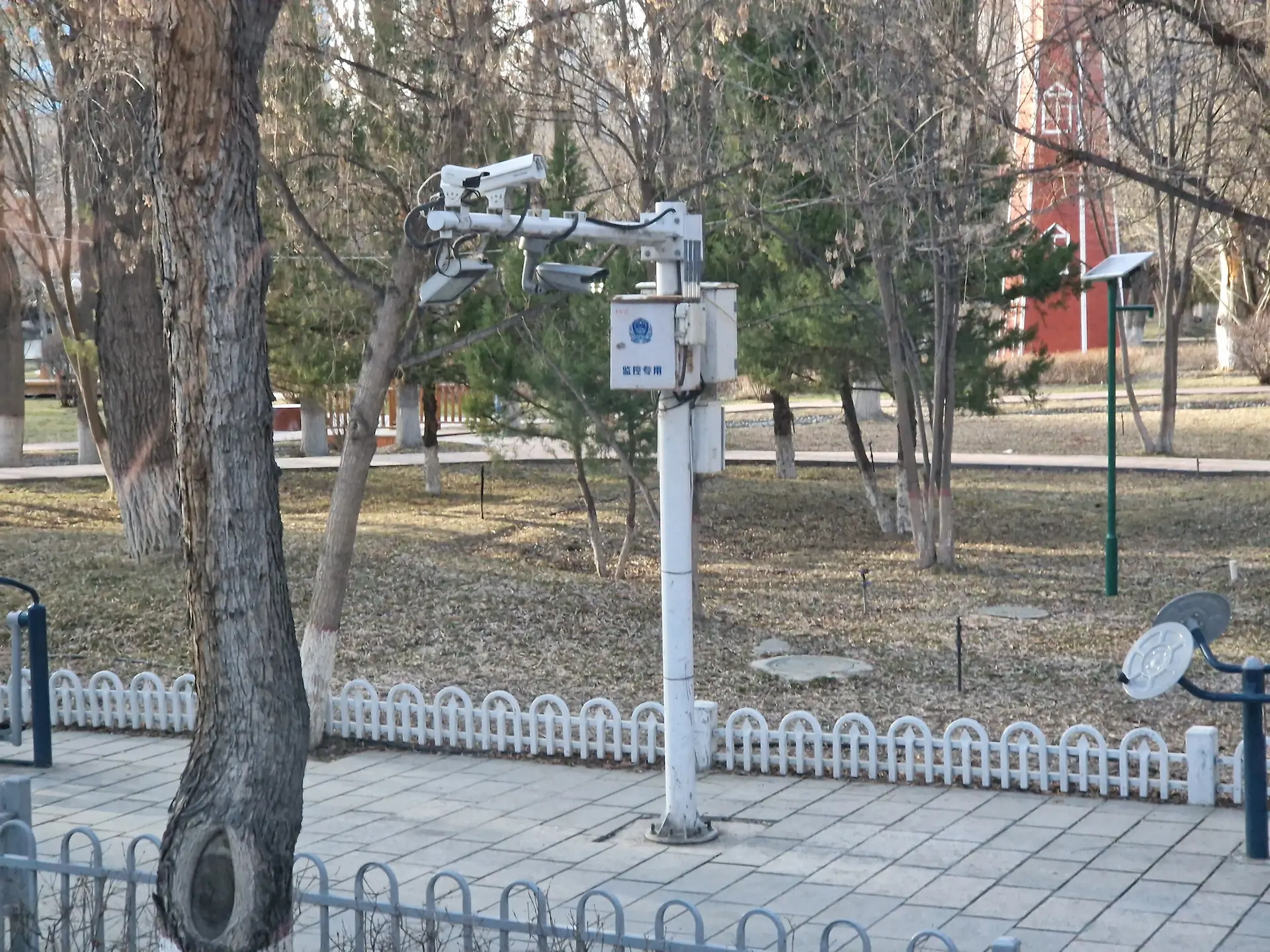 Sur un trottoir, quatre caméras se trouvent au sommet d'un poteau.