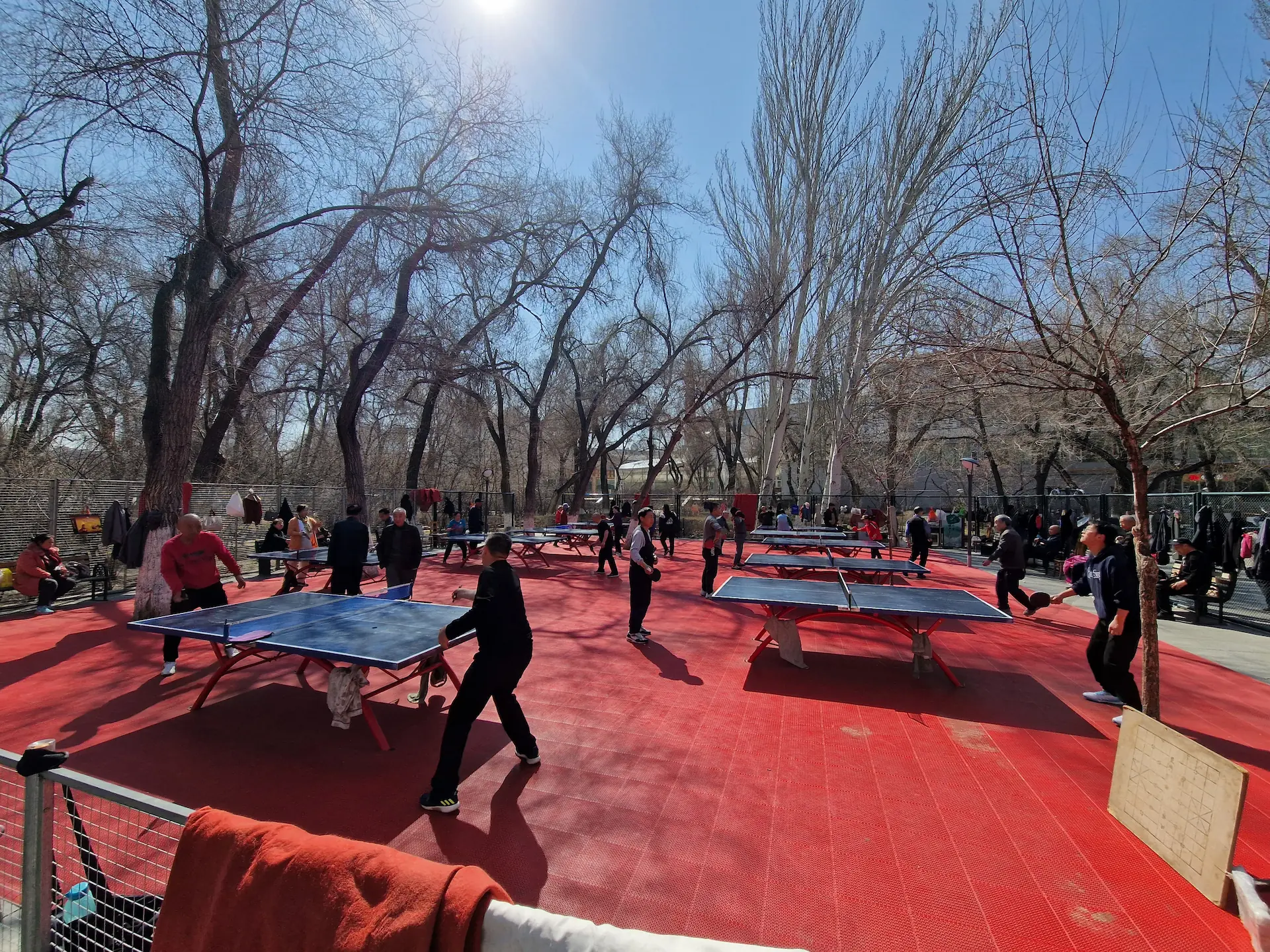 Un espace ping-pong très bien entretenu, où on voit huit tables en pleine partie.