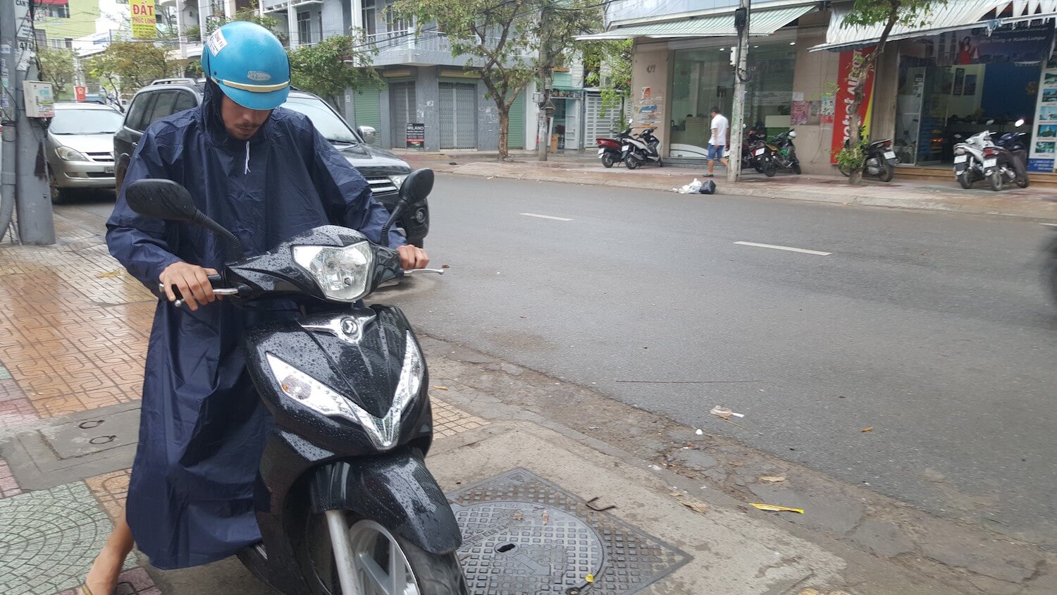 Robin en poncho sur le scooter à Nha Trang