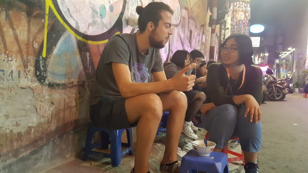 Robin et notre guide qui mangent de la street food à Hà Nội