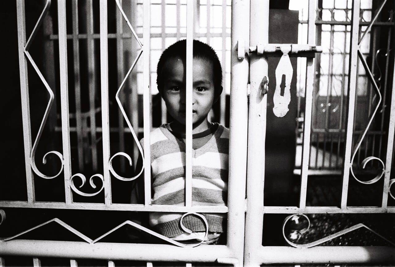 Un enfant derrière le portail de sa maison à Da Lat