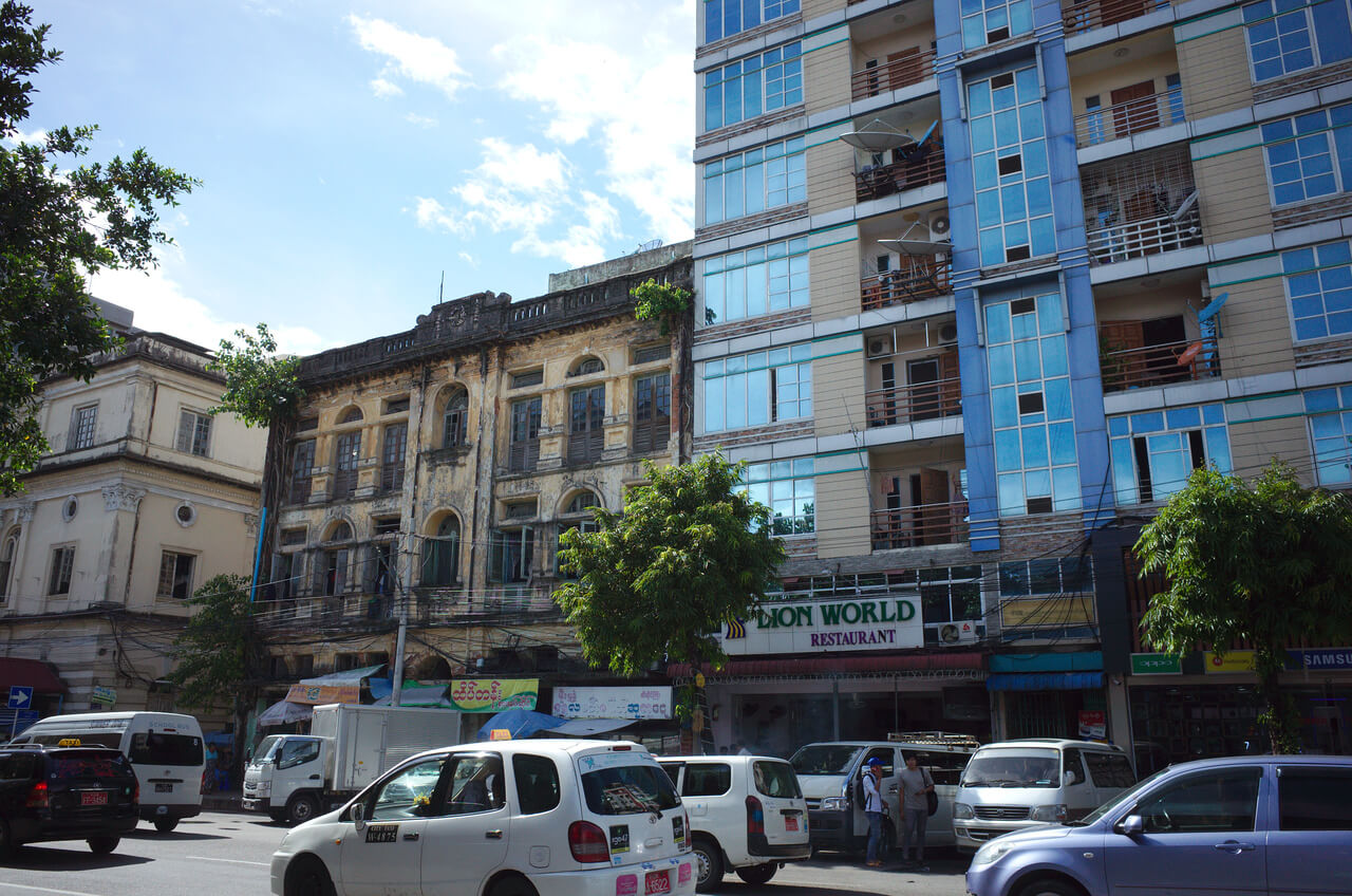 Un immeuble colonial contraste avec un immeuble moderne à Yangon