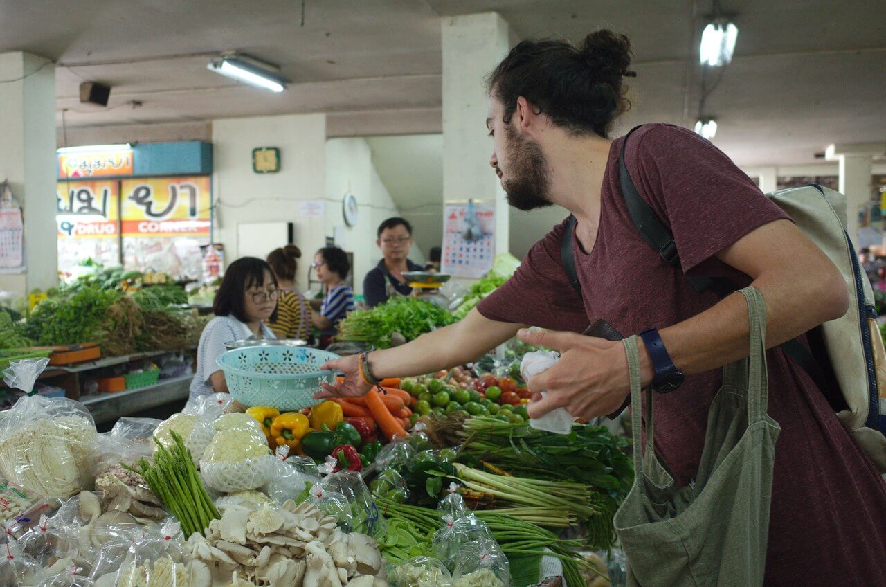 Robin achète des légumes au marché Thanin à Chiang Mai