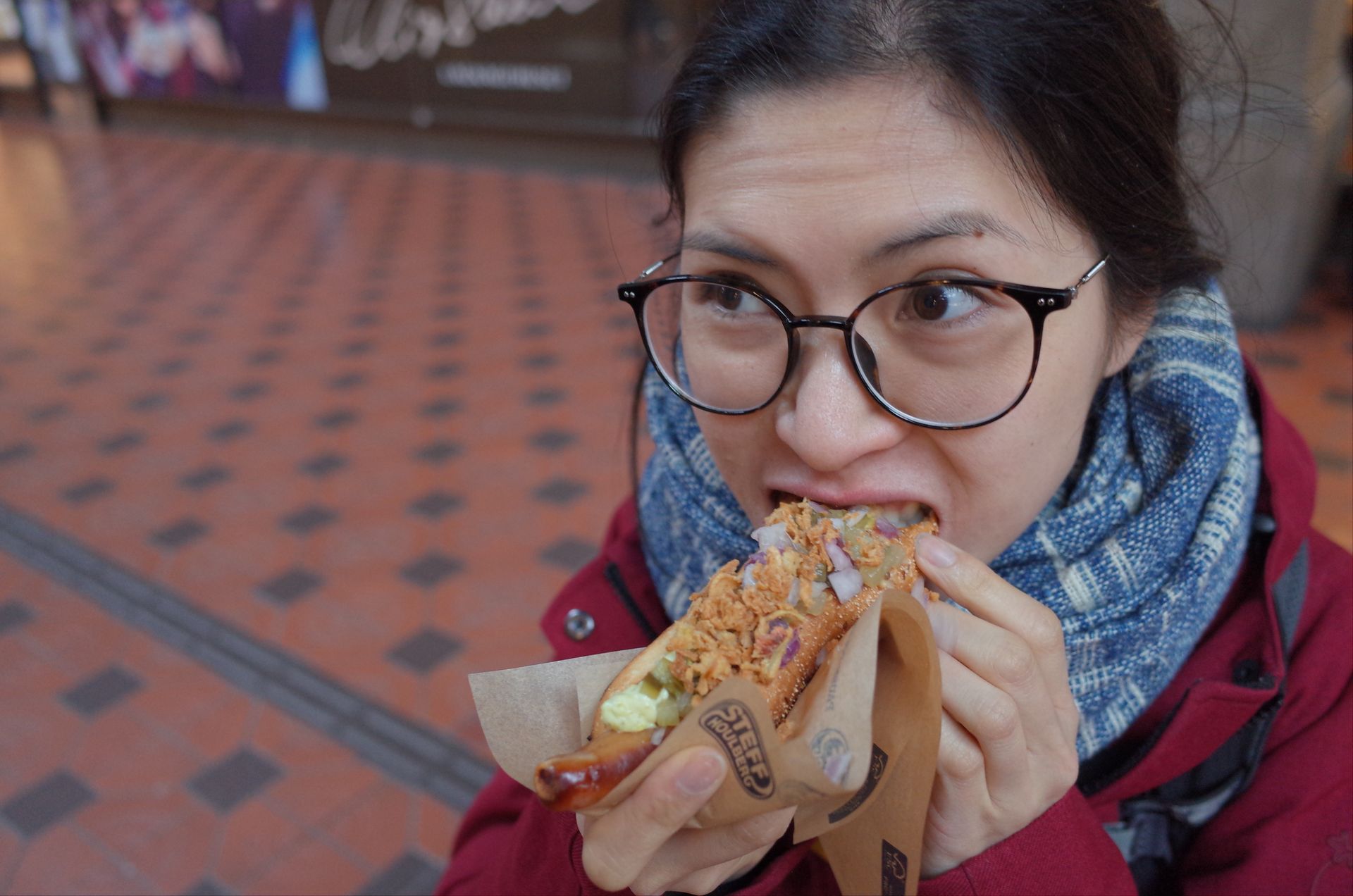 Clara mange un hot dog à la gare de Copenhague