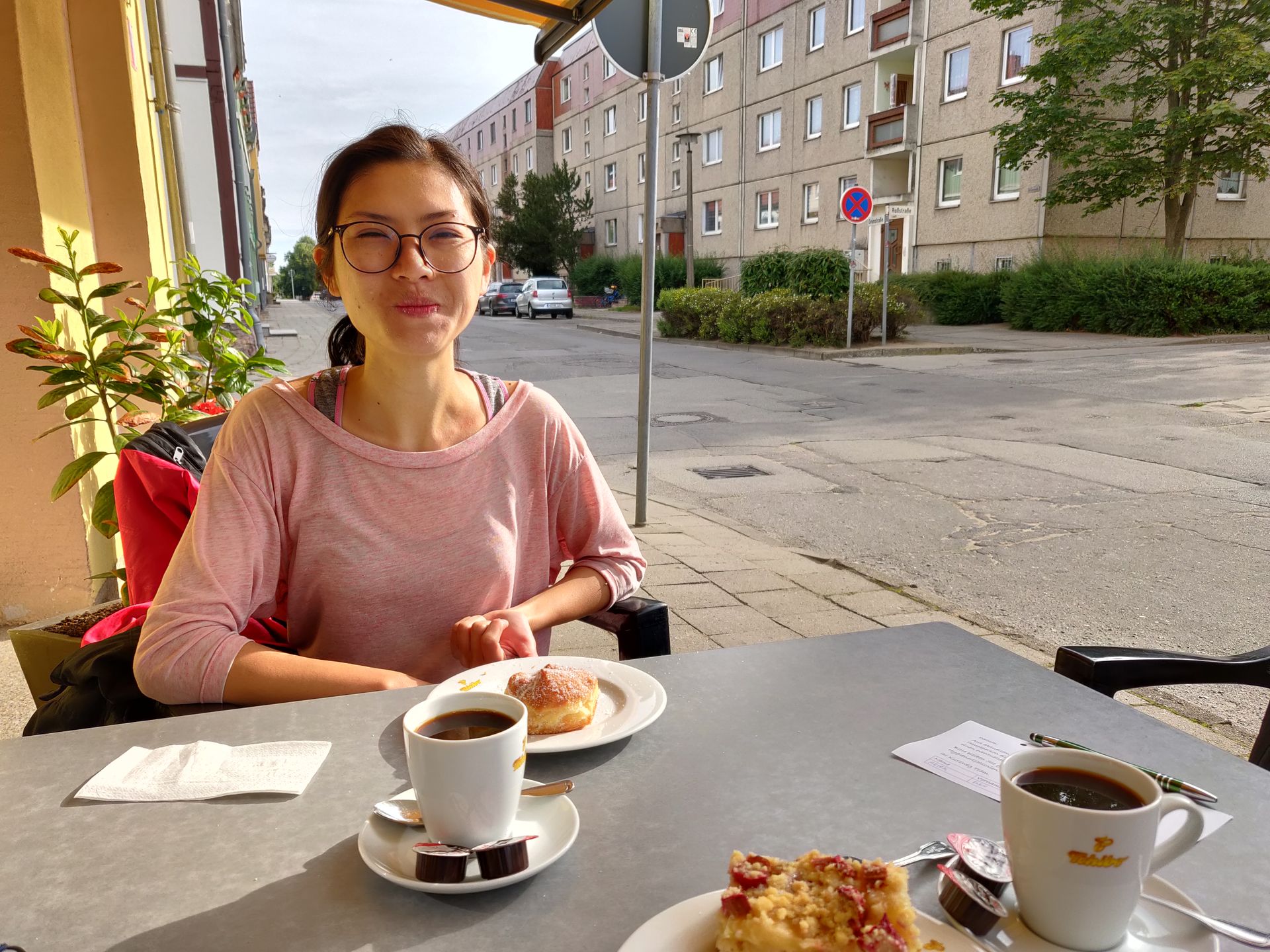 Clara mange un petit dej sur la terrasse ensoleillée d'une boulangerie à Pasewalk