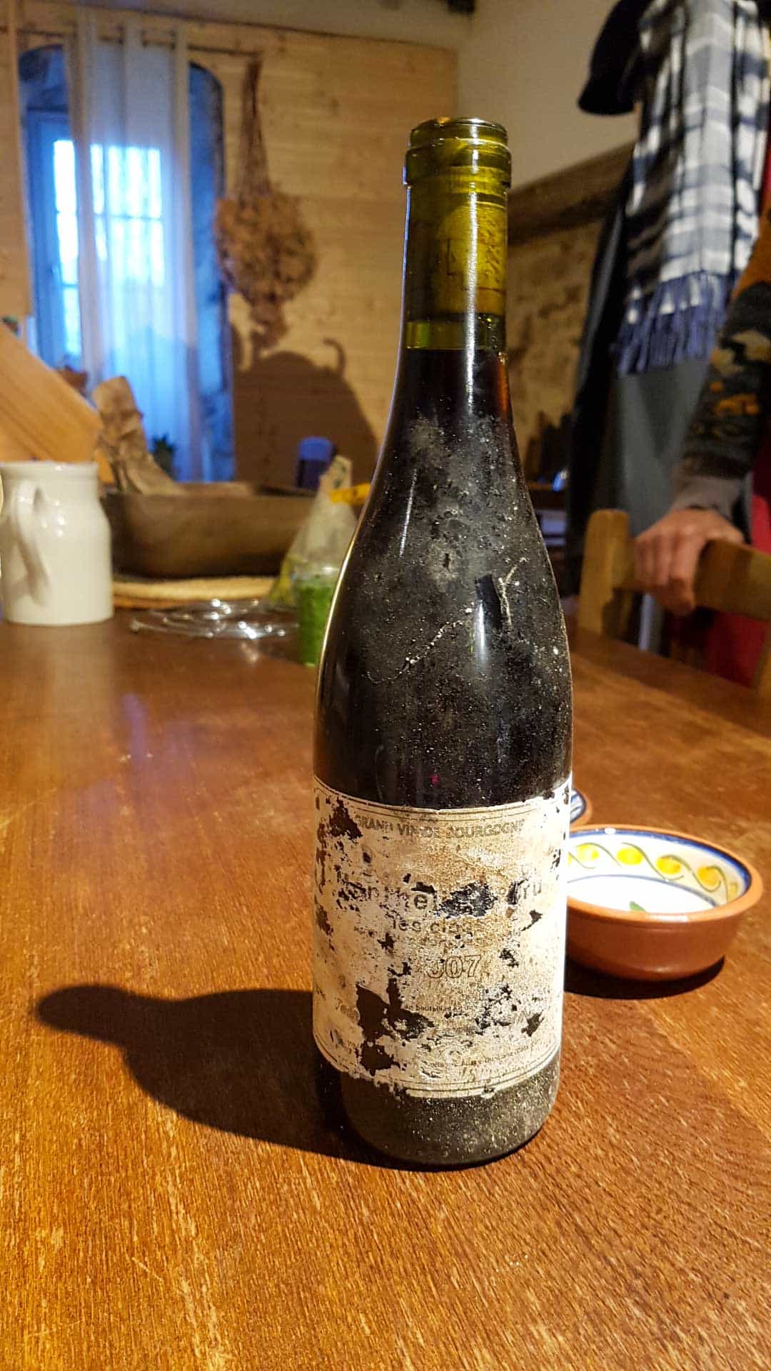 Vieille bouteille de vin rouge à l'étiquette tombant en miettes