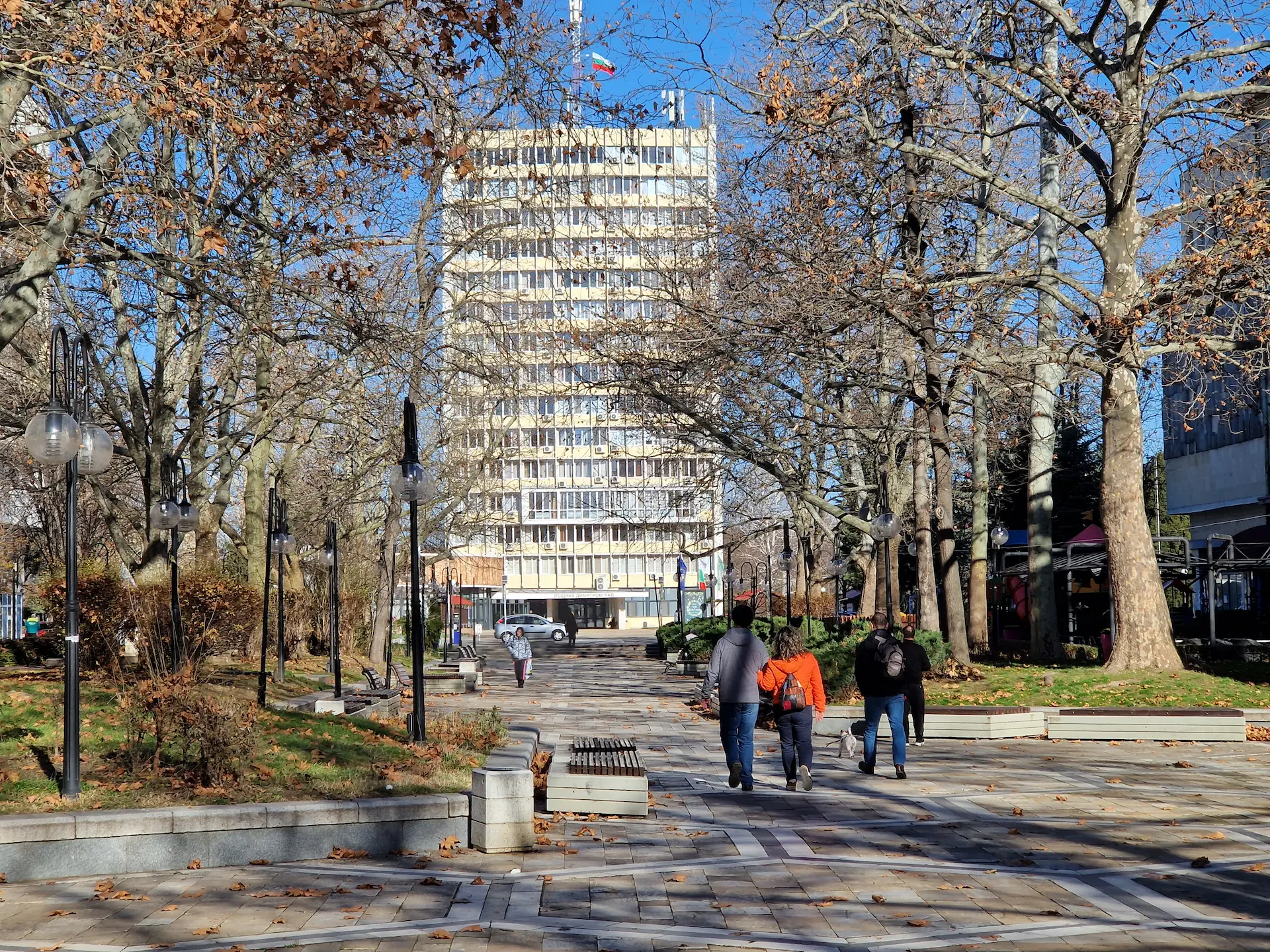 Le boulevard Bulgaria, la rue est pavée et bordée d'arbres, au fond on voit une grande tour blanche