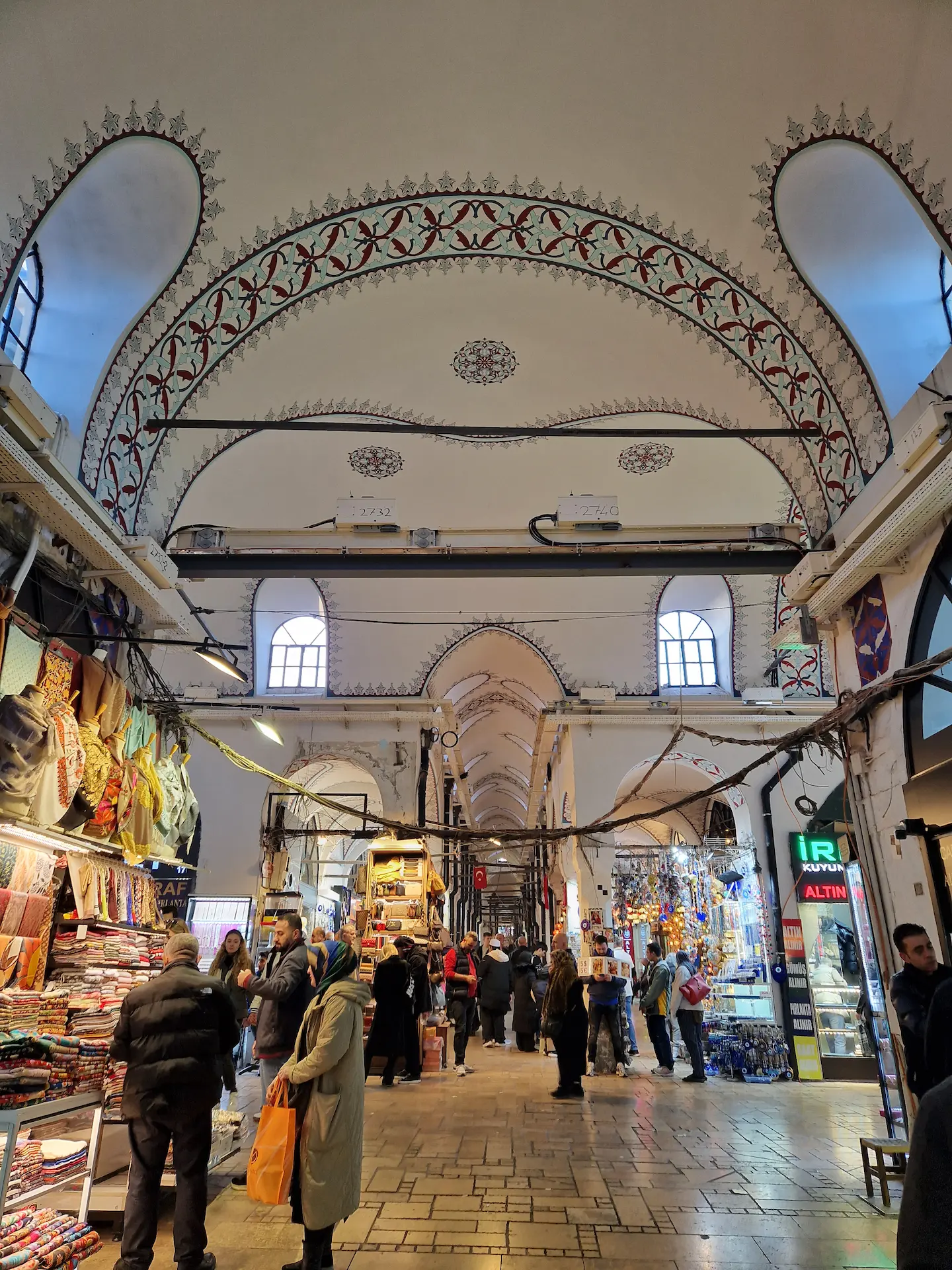 Grand bazar d'Istanbul. Belles arches blanches avec des détails peints en rouge, échoppes illuminées, du monde mais pas trop.