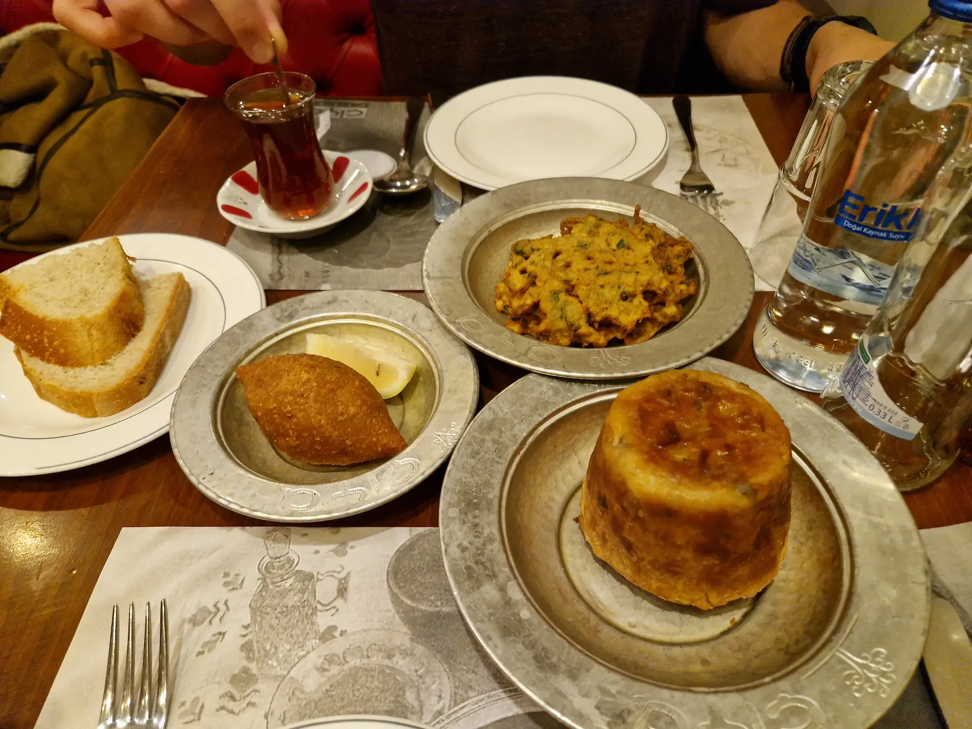Dans des petits plats en métal, on voit quelques petits plats : perde pilavı, içli köfte et galettes de légumes.