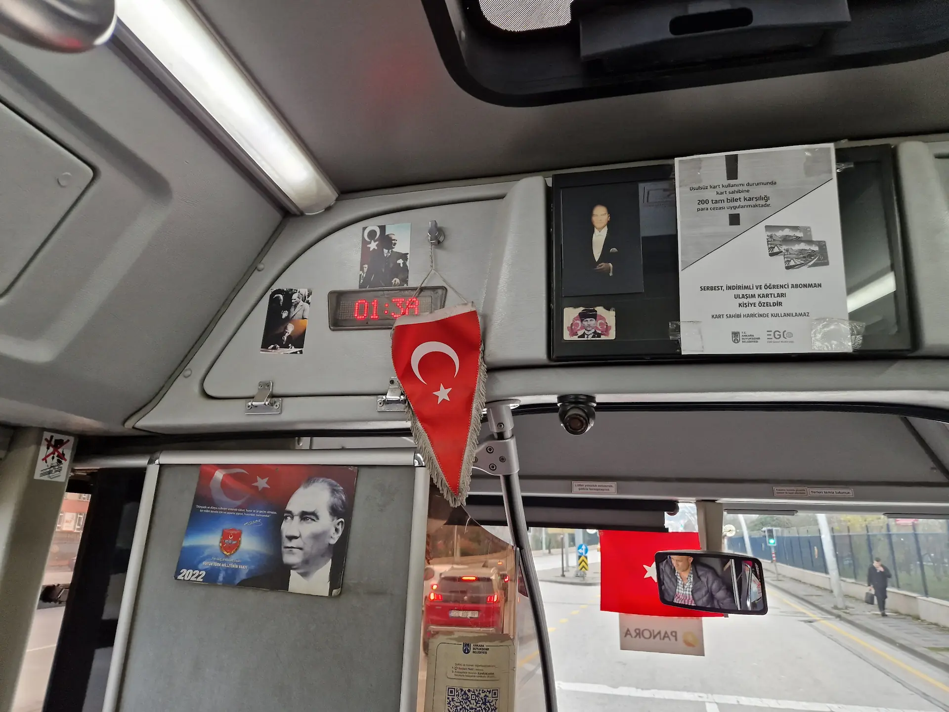 Différents posters et bannières sont accrochés à l'avant d'un bus : portrait d'Atatürk en couleur, portrait en noir et blanc sur fond de drapeau turc rouge, un drapeau turc simple, etc.
