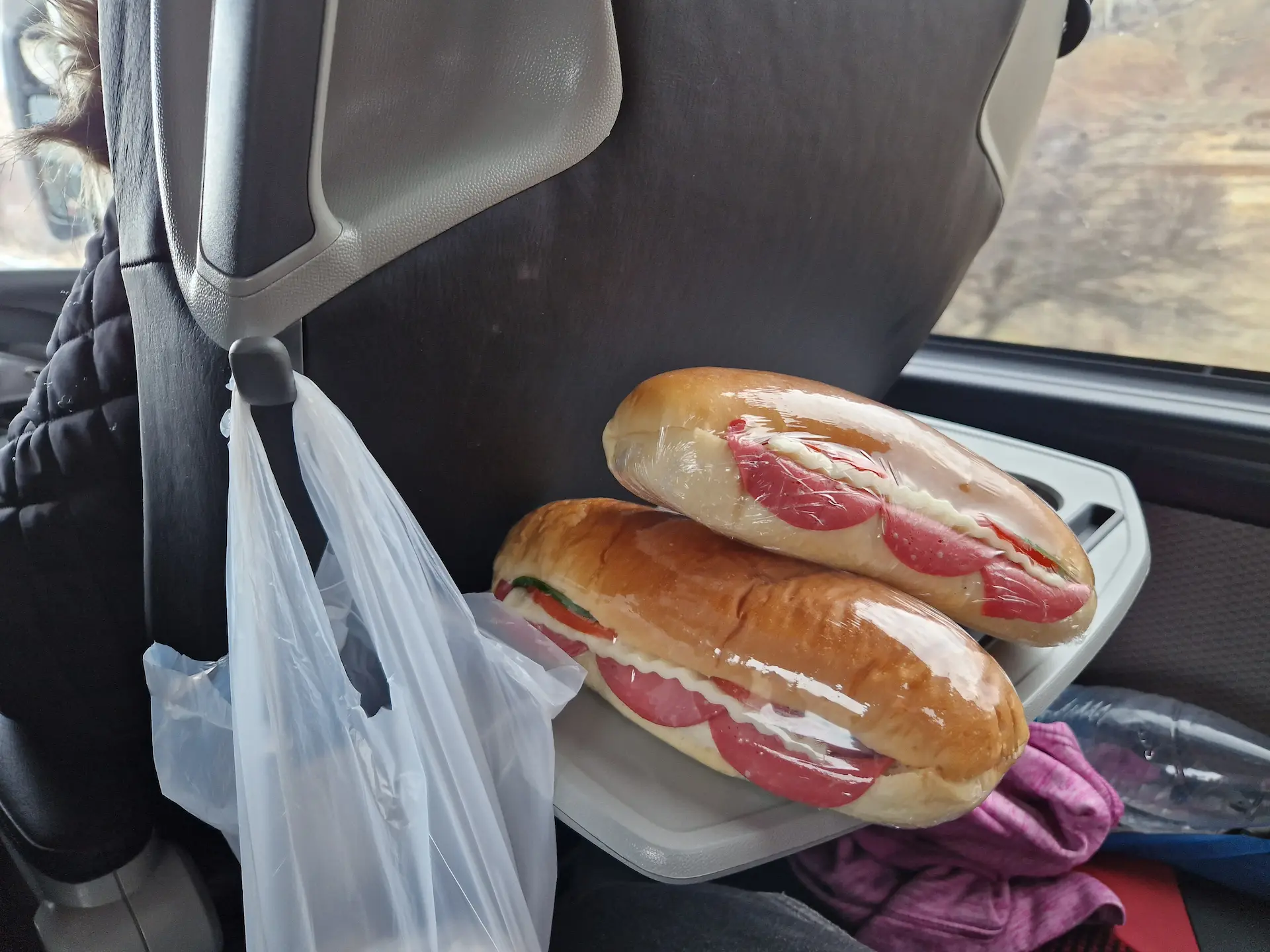 Deux sandwichs sous cellophane, on voit le jambon rose pétant, fromage et concombre déborder sur le côté