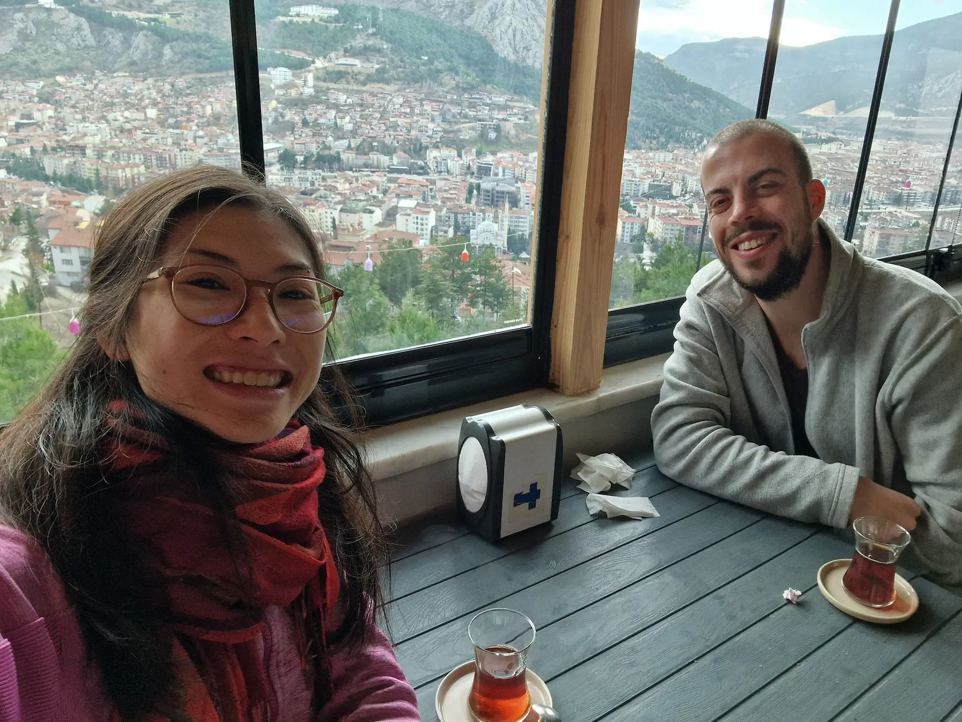 Selfie de Clara et Robin avec leur thé chaud. En fond, la ville d'Amasya vue d'en haut.