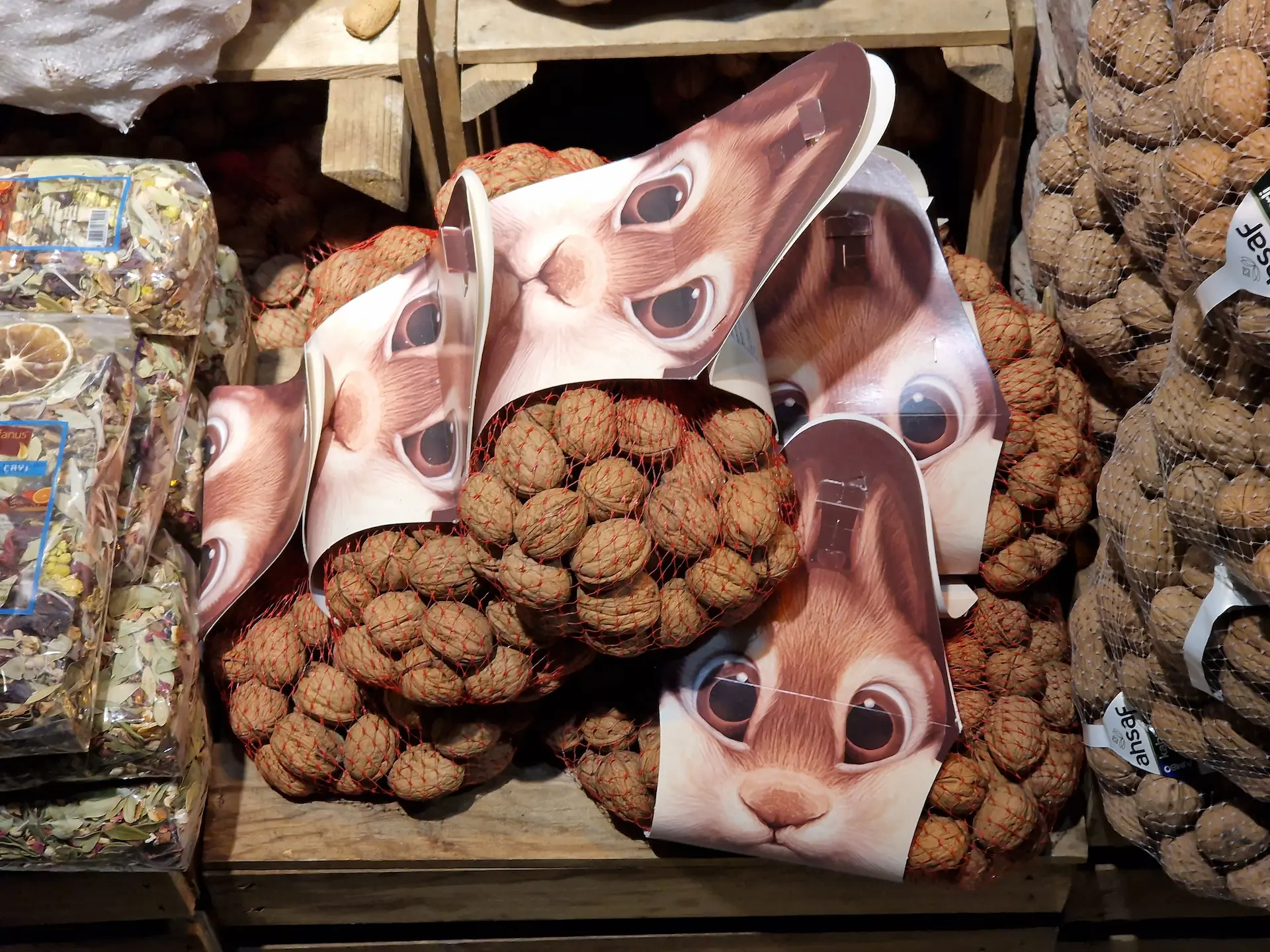 Des sacs de noix en vente, le paquet est en carton avec un dessin de tête d'écureuil, les noix dépassent là où seraient les joues