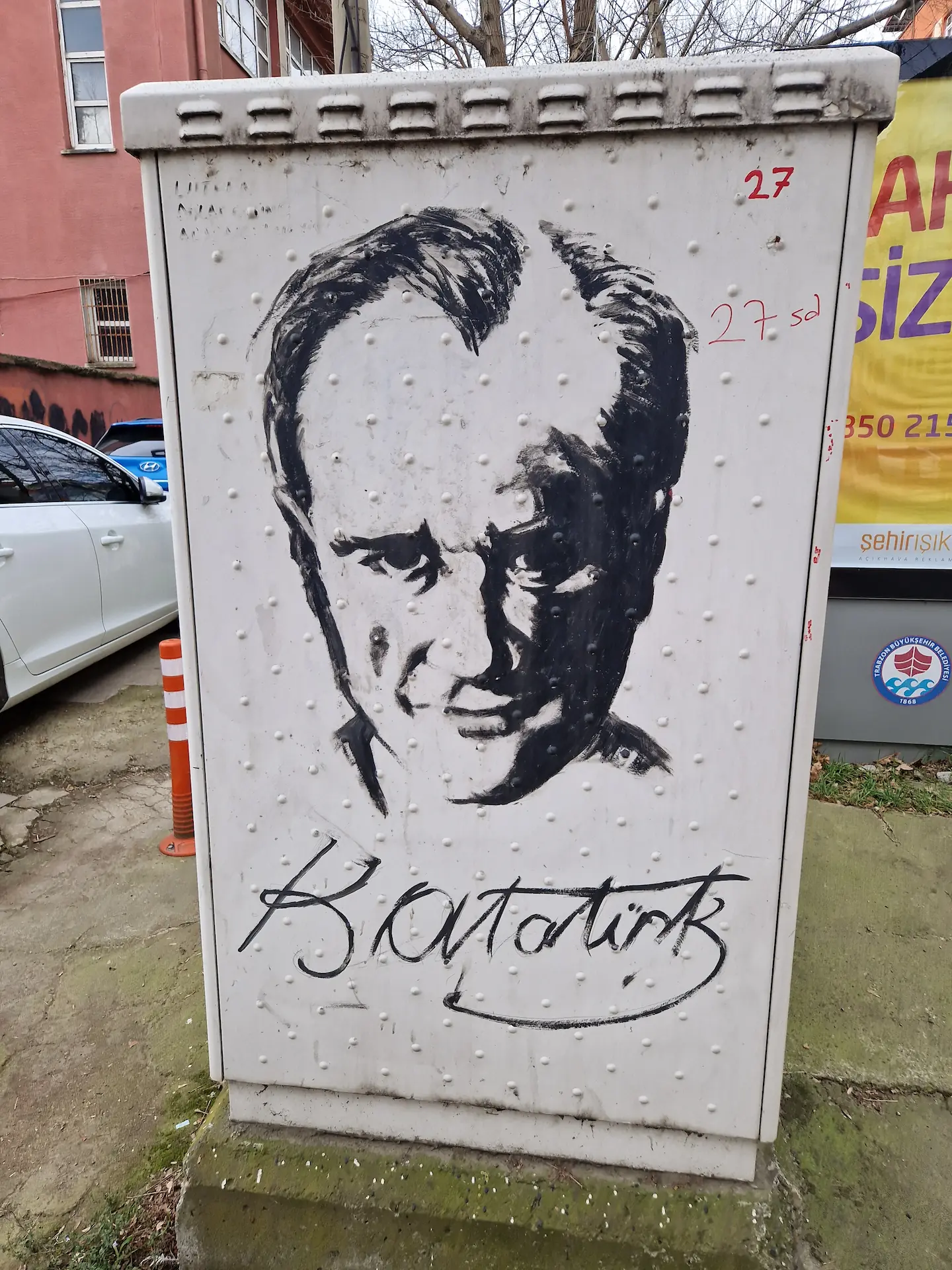 Sur une boîte d'électronique de rue, un portrait d'Atatürk est peint en noir au pinceau.