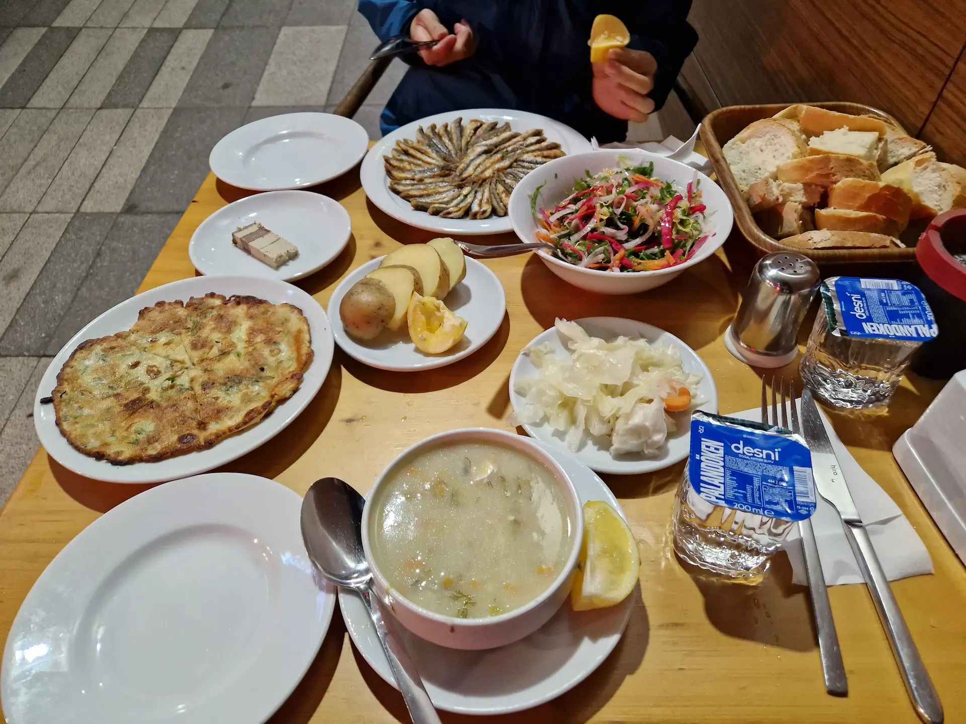 Une petite table dans une ruelle de Trabzon couverte de plats de poisson et d'accompagnements.
