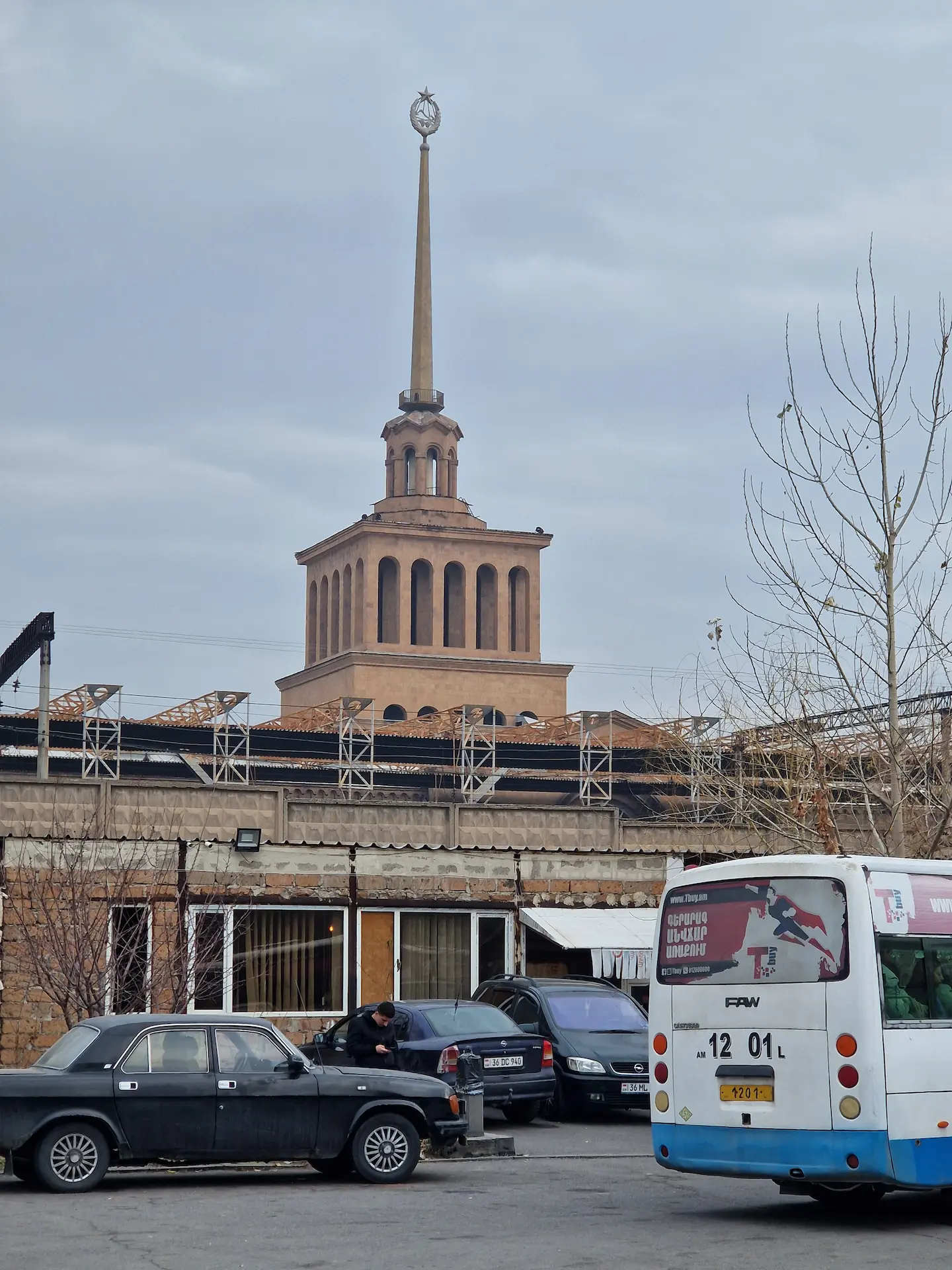 La gare de Yerevan vue de l'extérieur et de jour. Le bâtiment est décoré de colonnes et d'une immense pointe terminée en une étoile socialiste.