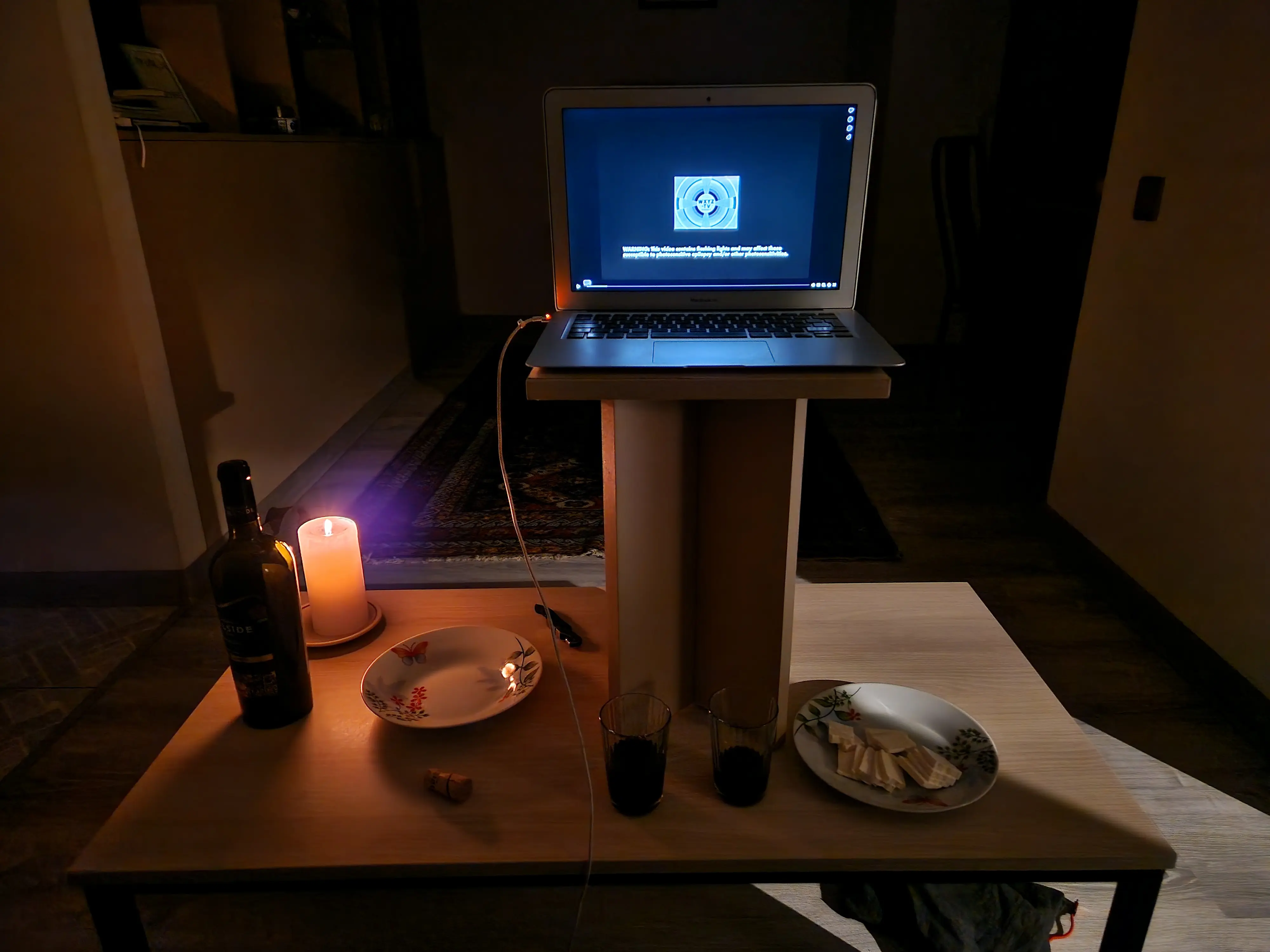 Notre setup de film à la maison, le laptop de Robin est posé sur un tabouret en équilibre sur la table-basse du salon. On a allumé une bougie, fait une petite assiette de fromage, et ouvert une bouteille de vin azéri.
