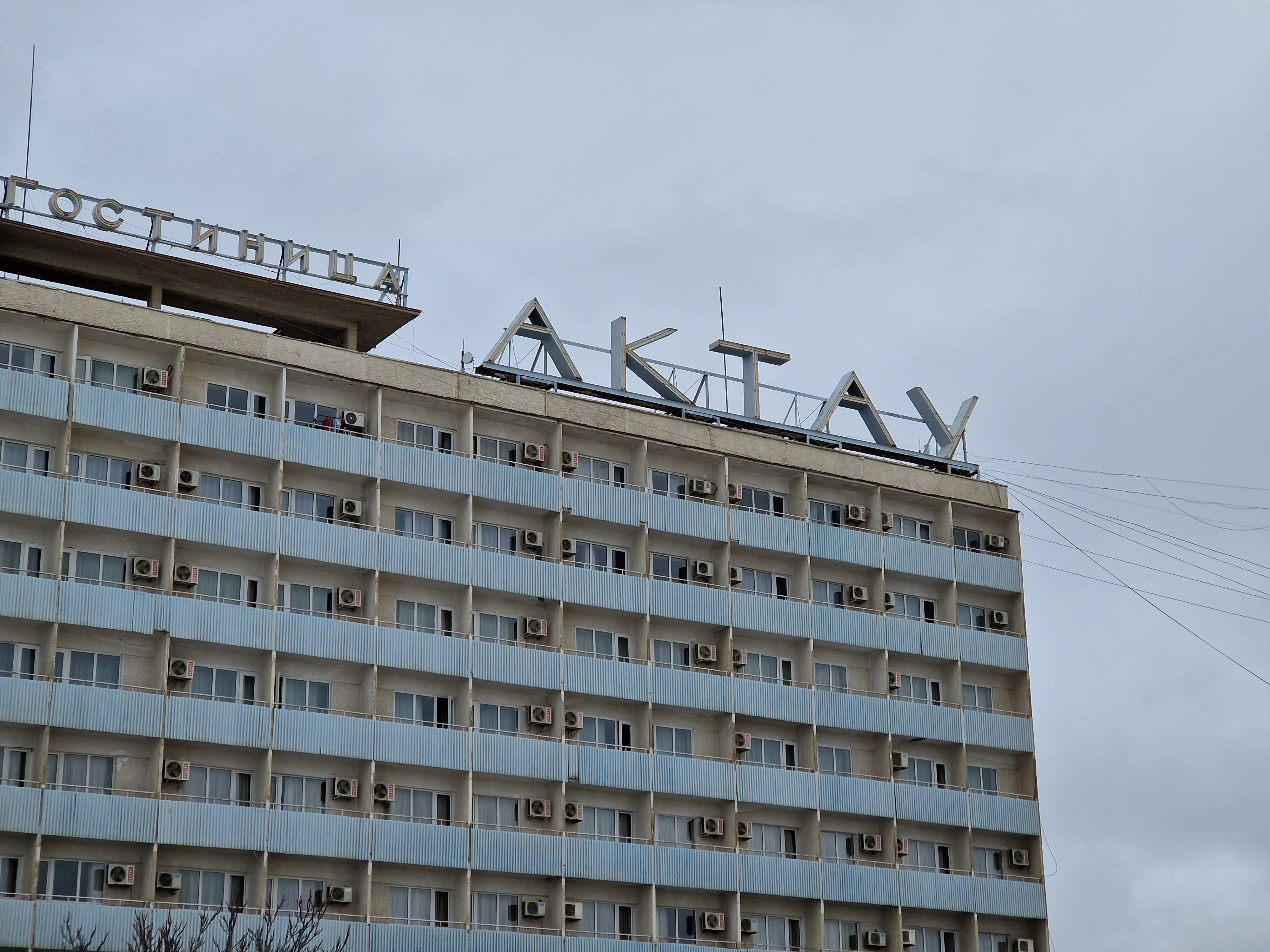 Un immeuble au style soviétique avec un grand signe "Актау" (Aktau en cyrillique russe) à son sommet