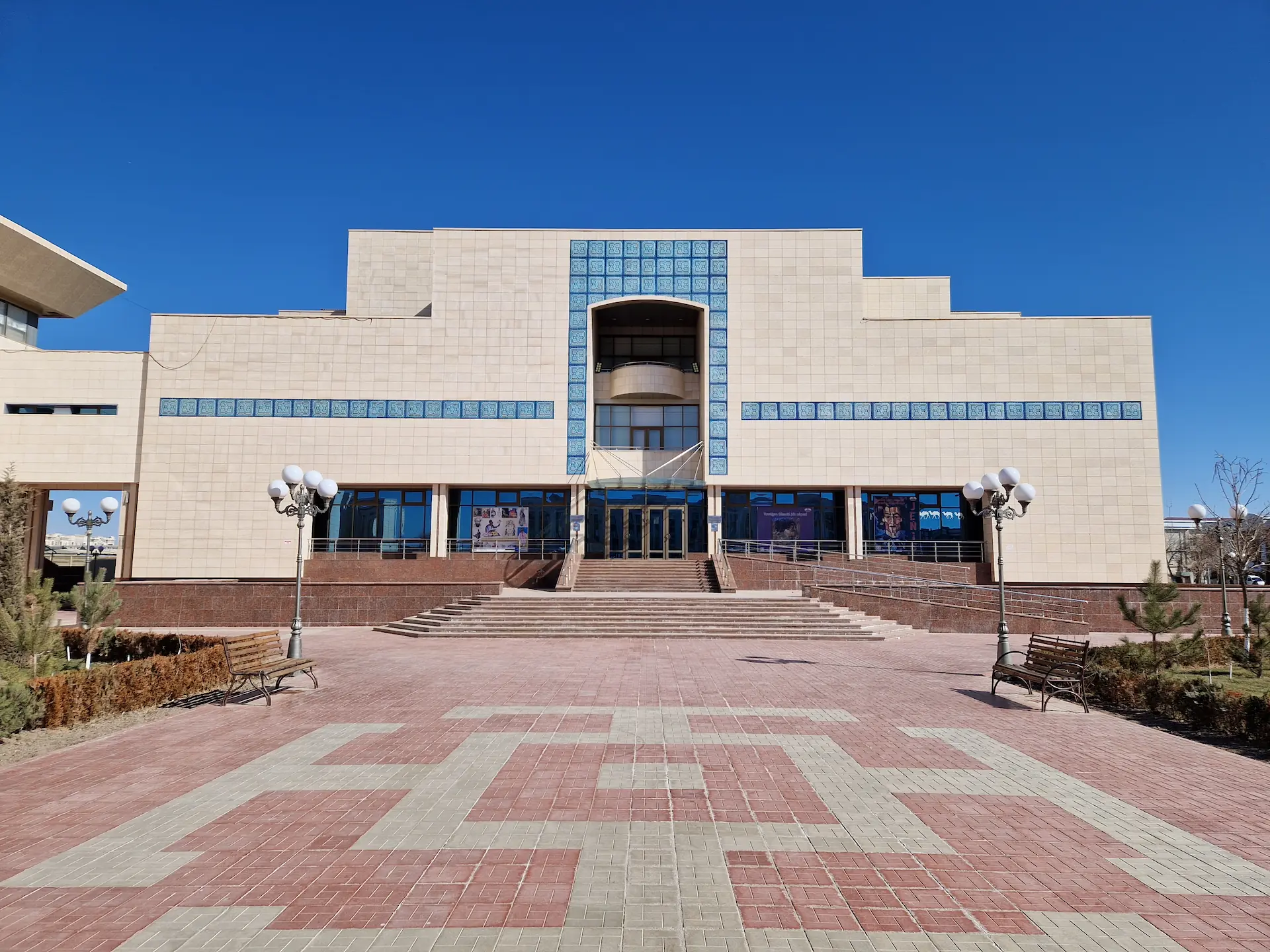 La façade impressionnante du musée vue de face, gros bloc blancs coupé d'une ligne horizontale bleue. L'arche lignée de bleu au-dessus de la porte rappelle un peu l'architecture des madrassas de Timour, version brutaliste.