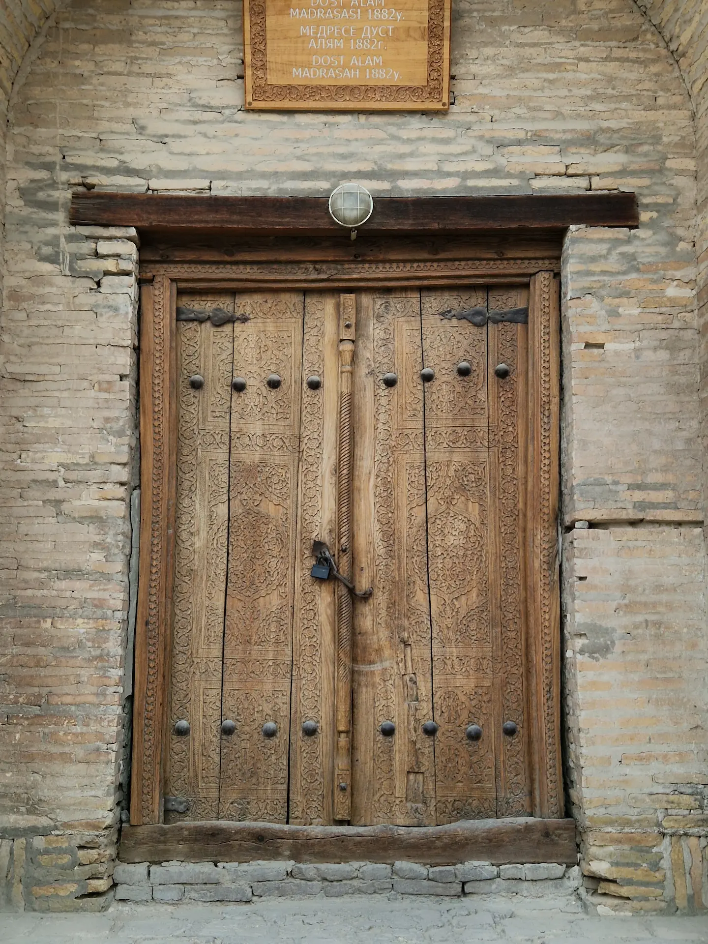 Une porte en bois gravée de motifs sur toute sa surface