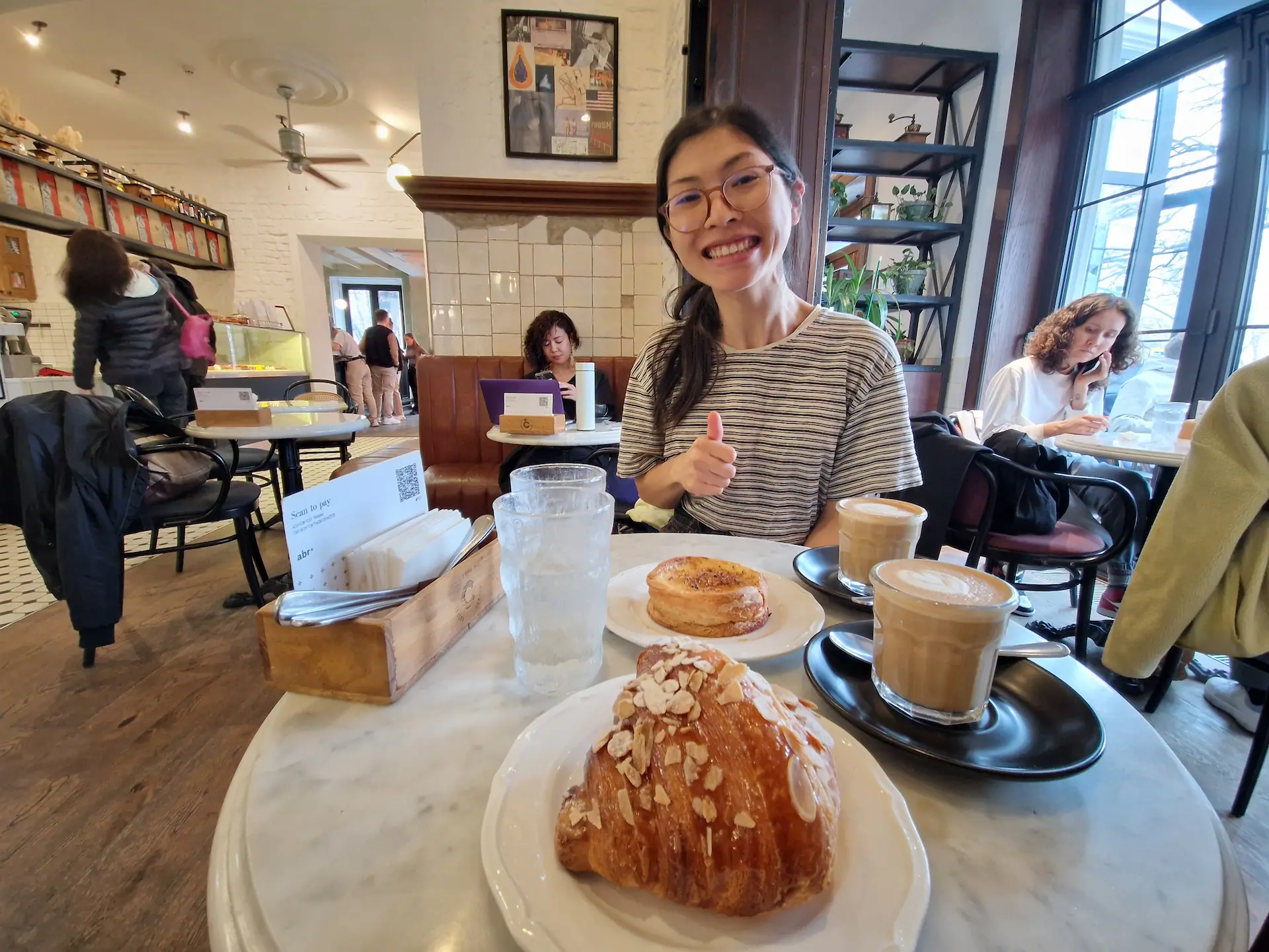 Clara avec un café et des pâtisseries à un café d'Almaty