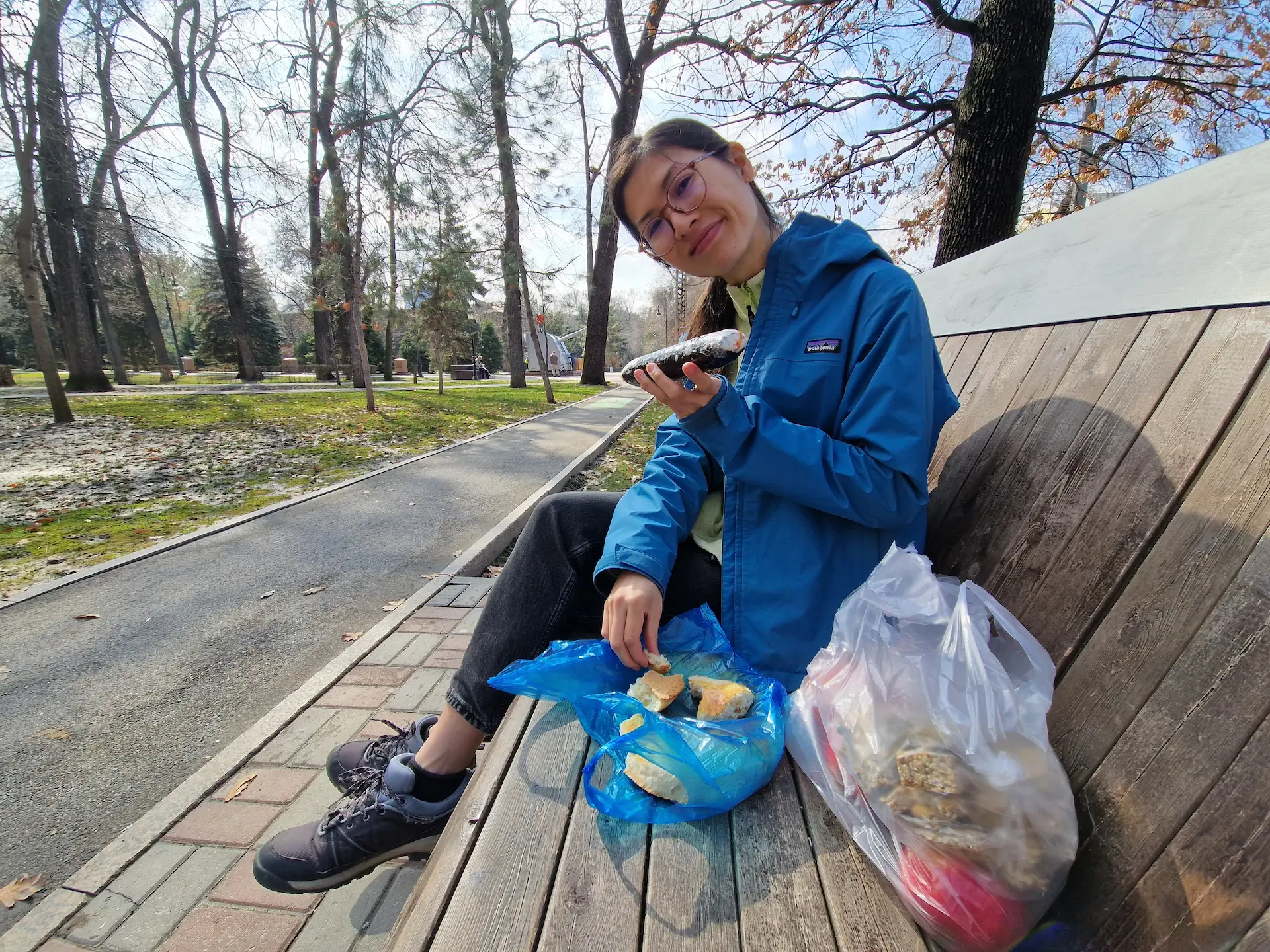Sur un banc dans un parc, Clara montre un rouleau de gimbap coréen