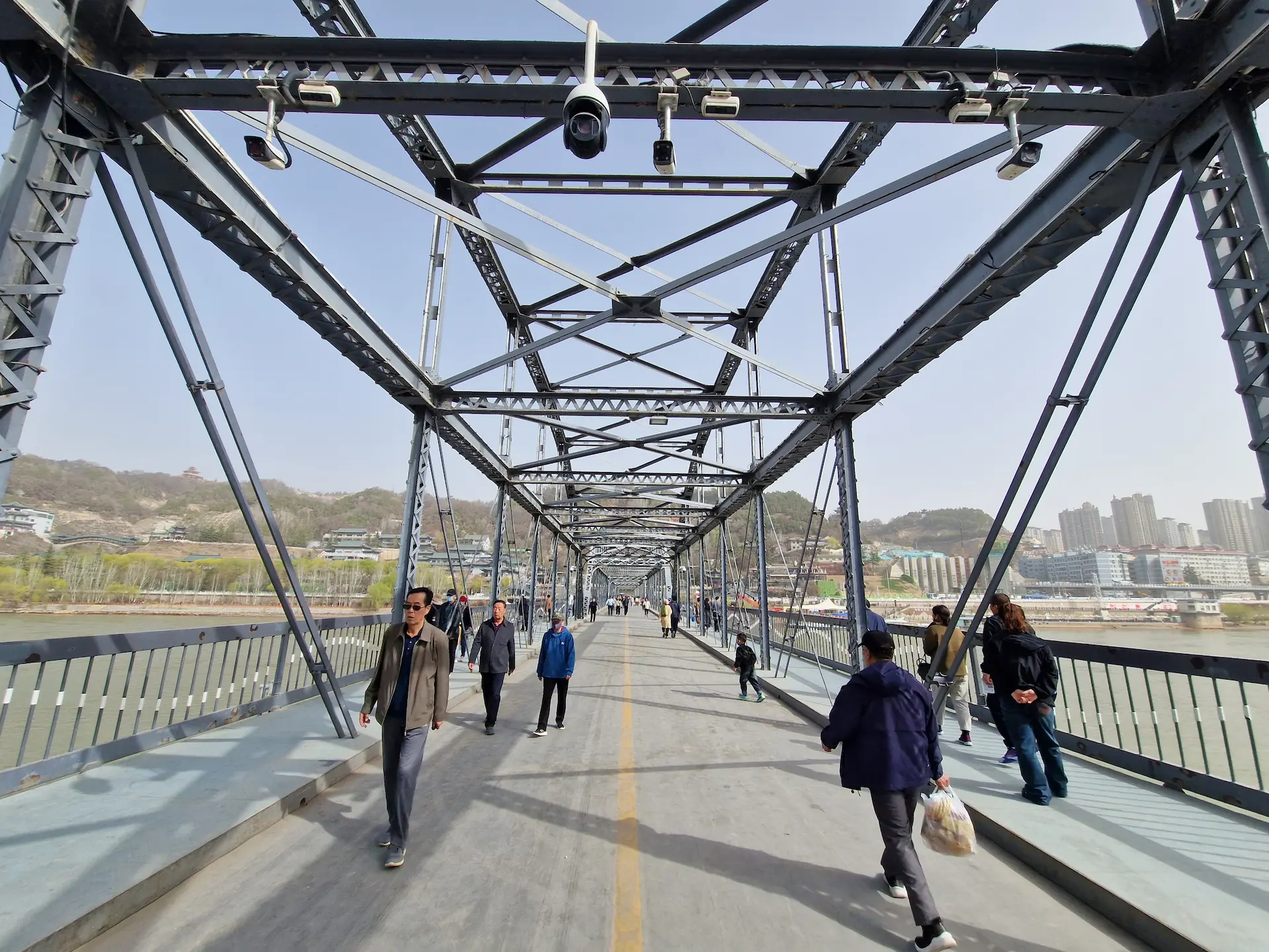 Pont d'acier piéton au-dessus du fleuve Jaune, du monde traverse dans les deux sens