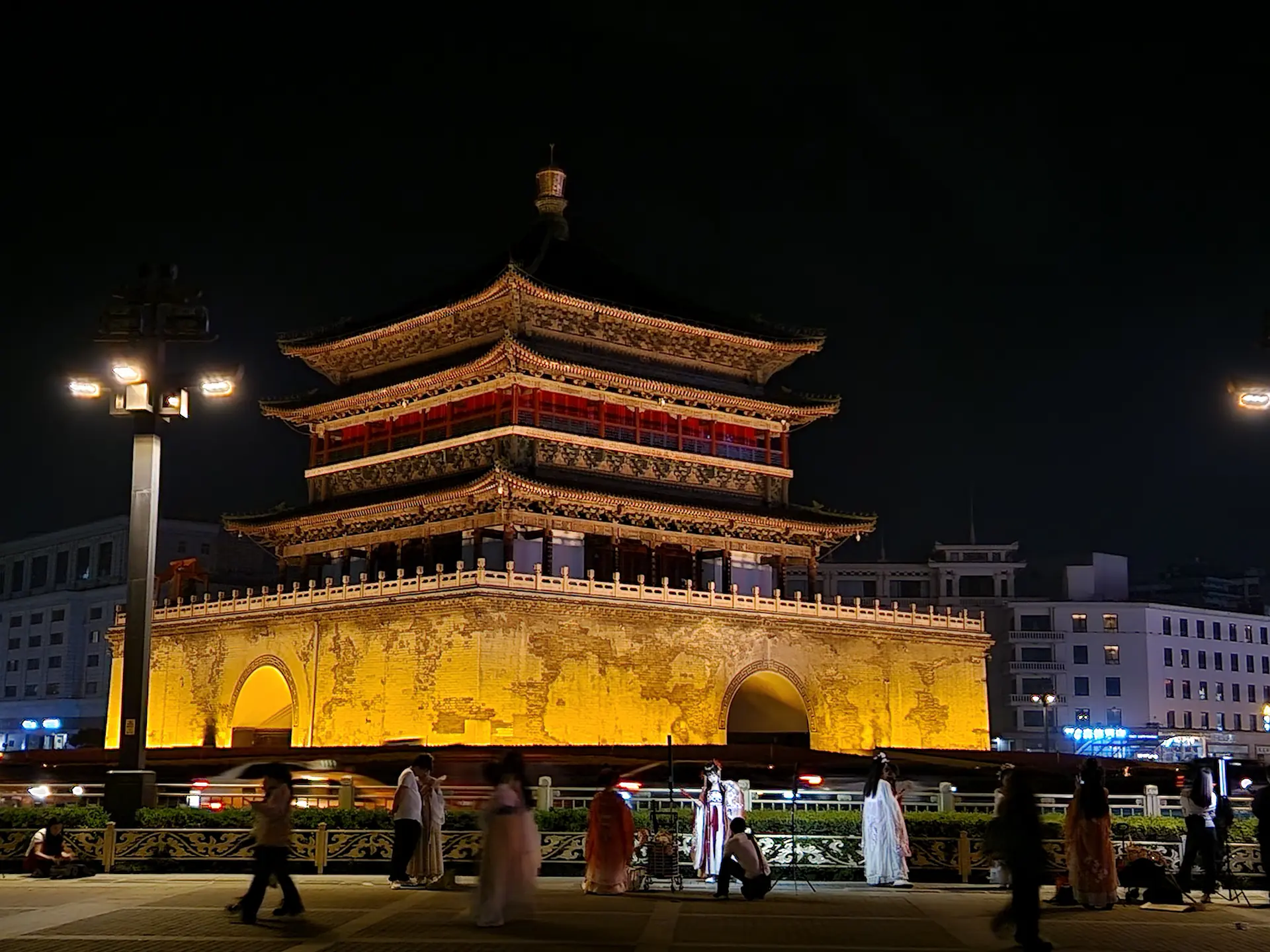 La tour de la cloche de Xi'an, illuminée de nuit. Devant, on voit les lumières blanches des shootings en cours.