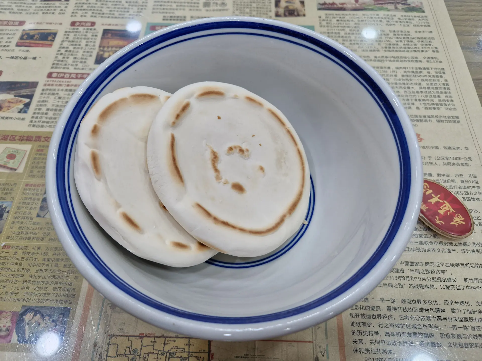 Un bol avec deux petits pains plats circulaires mó posés dedans