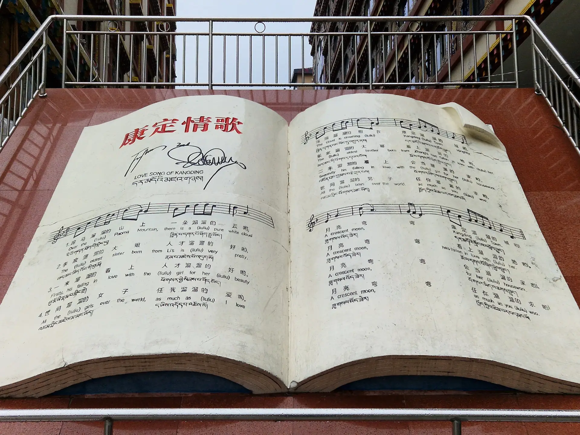 Statue d'un livre de partitions ouvert à la page de la Chanson d'amour de Kangding, avec paroles en chinois et en anglais