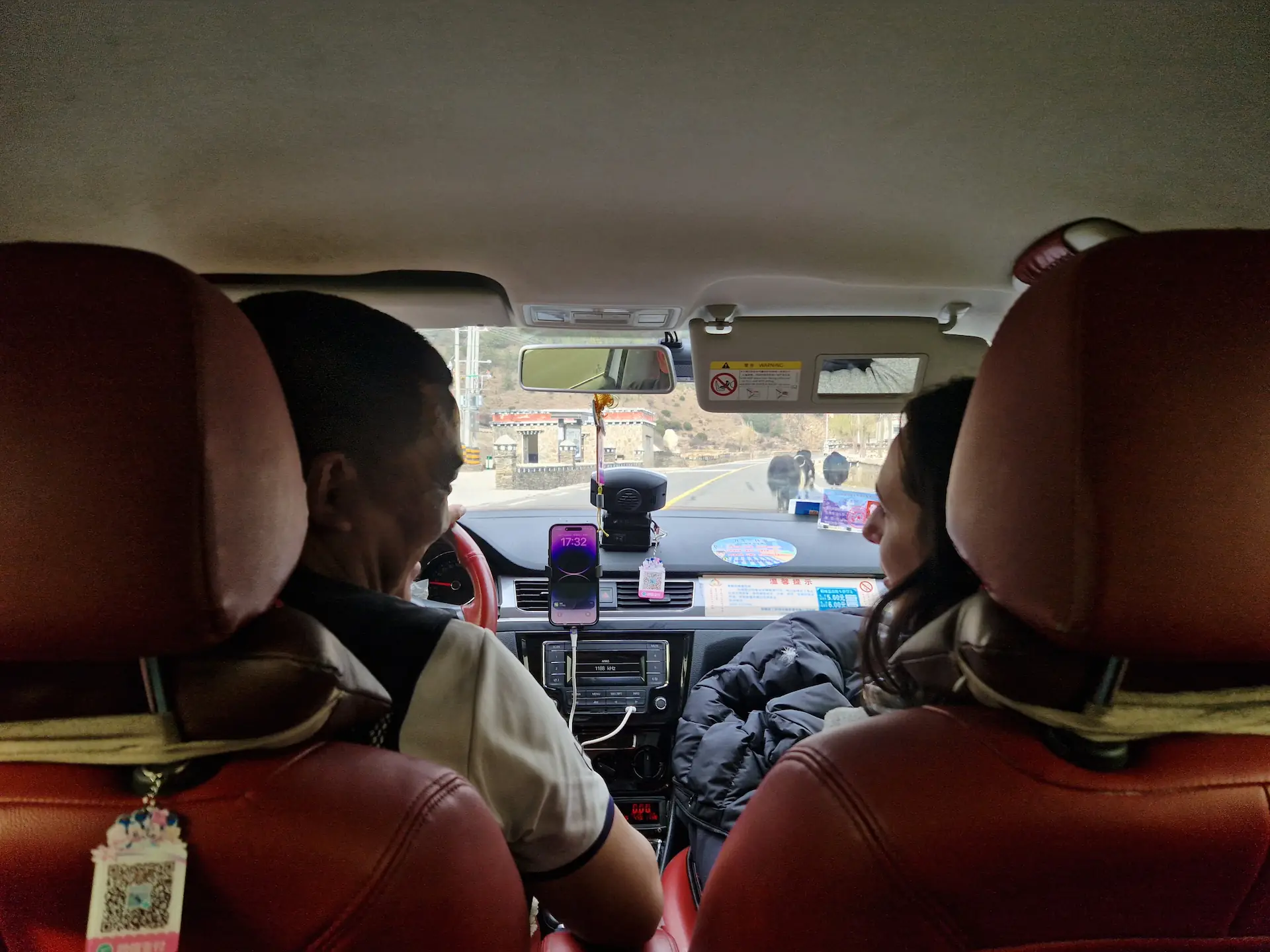 Micaela discute avec le chauffeur de taxi sur la route pour Daocheng.