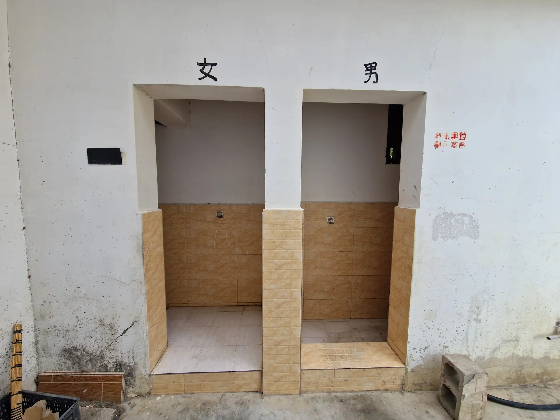 Toilettes publiques, deux portes marquées d'un caractère chinois, homme et femme probablement.