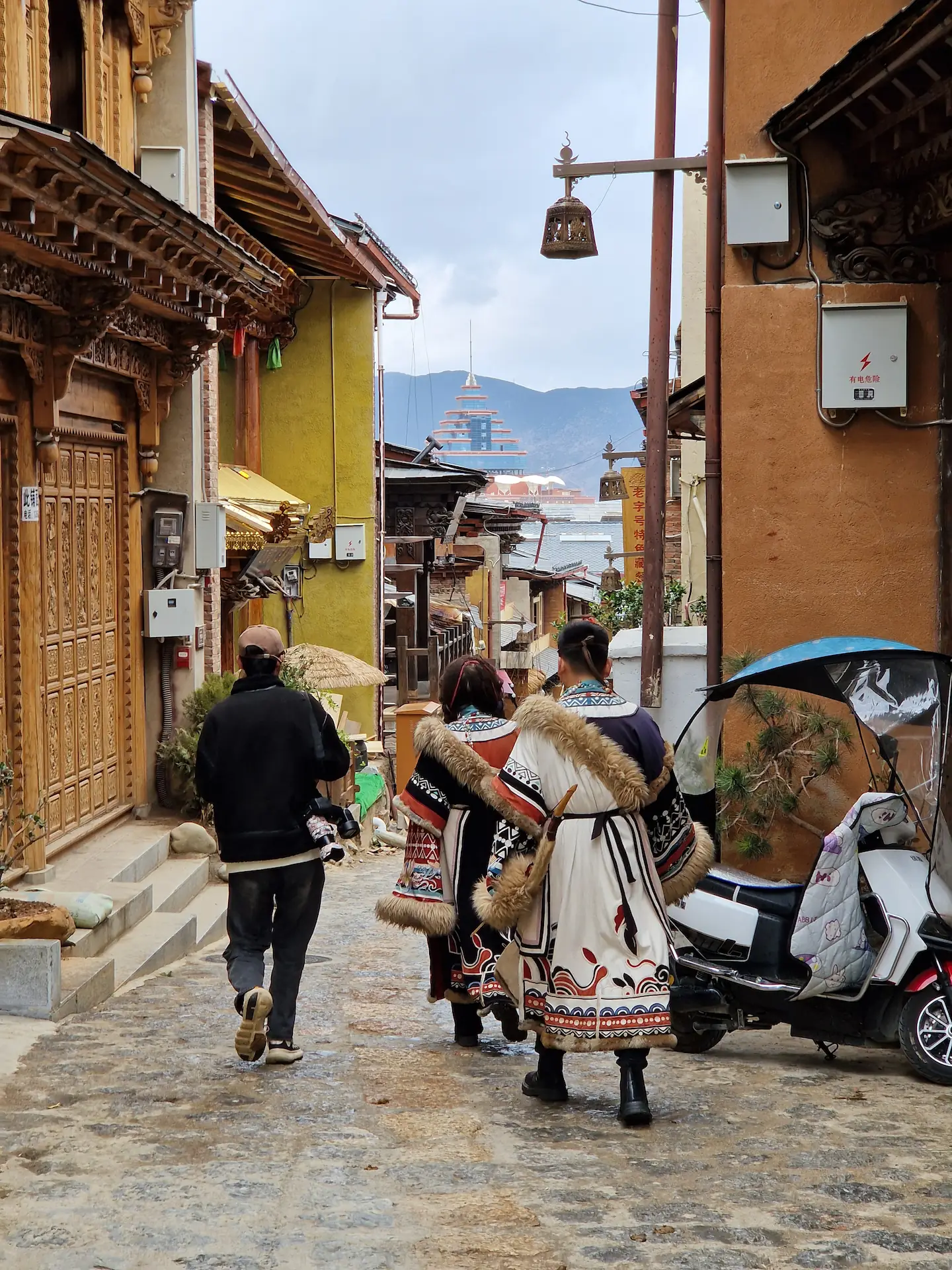 Un couple habillé en tibétains avec des fourrures et un arc, accompagné d'un photographe.