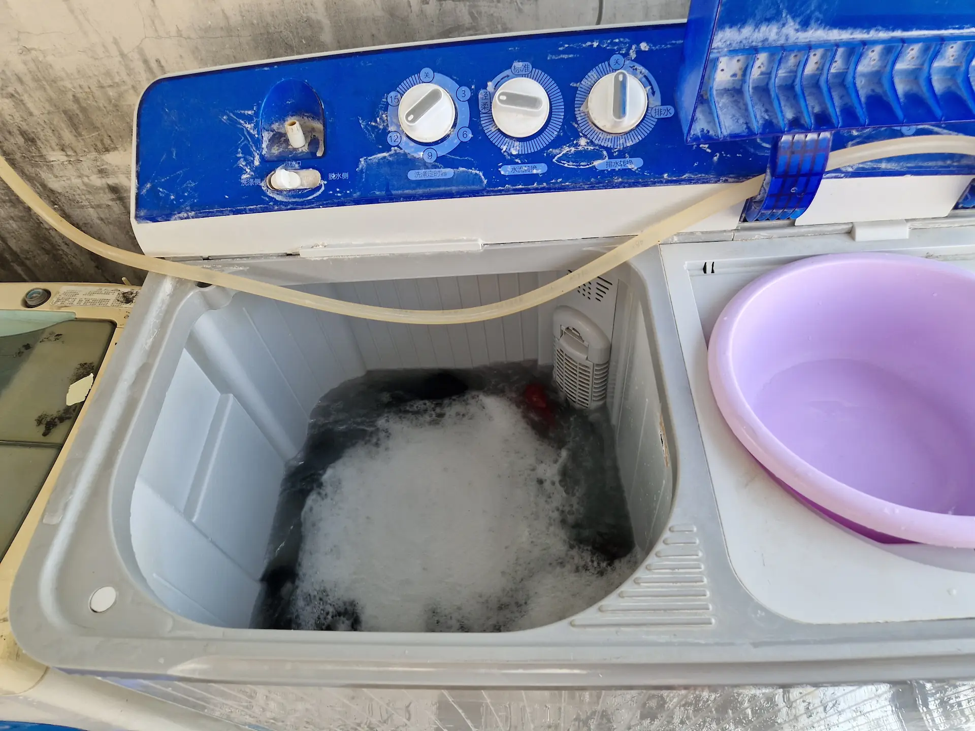 La machine à laver n'a pas de couvercle et est déjà préremplie d'eau.