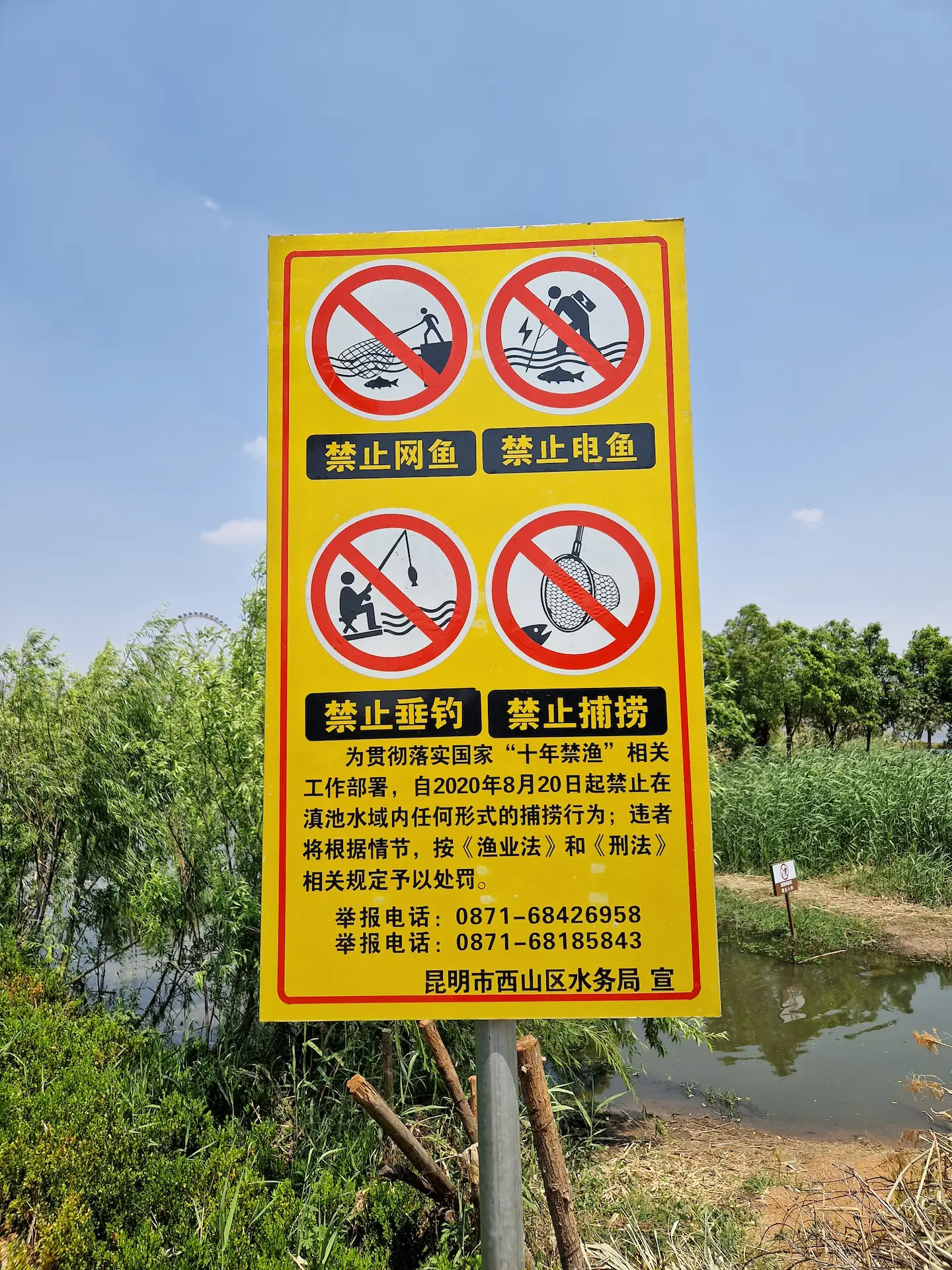 Au bord du lac, un panneau décrit plusieurs interdictions de pêche en tous genres (avec filet, au harpon, à la canne-à-pêche, au filet à main).