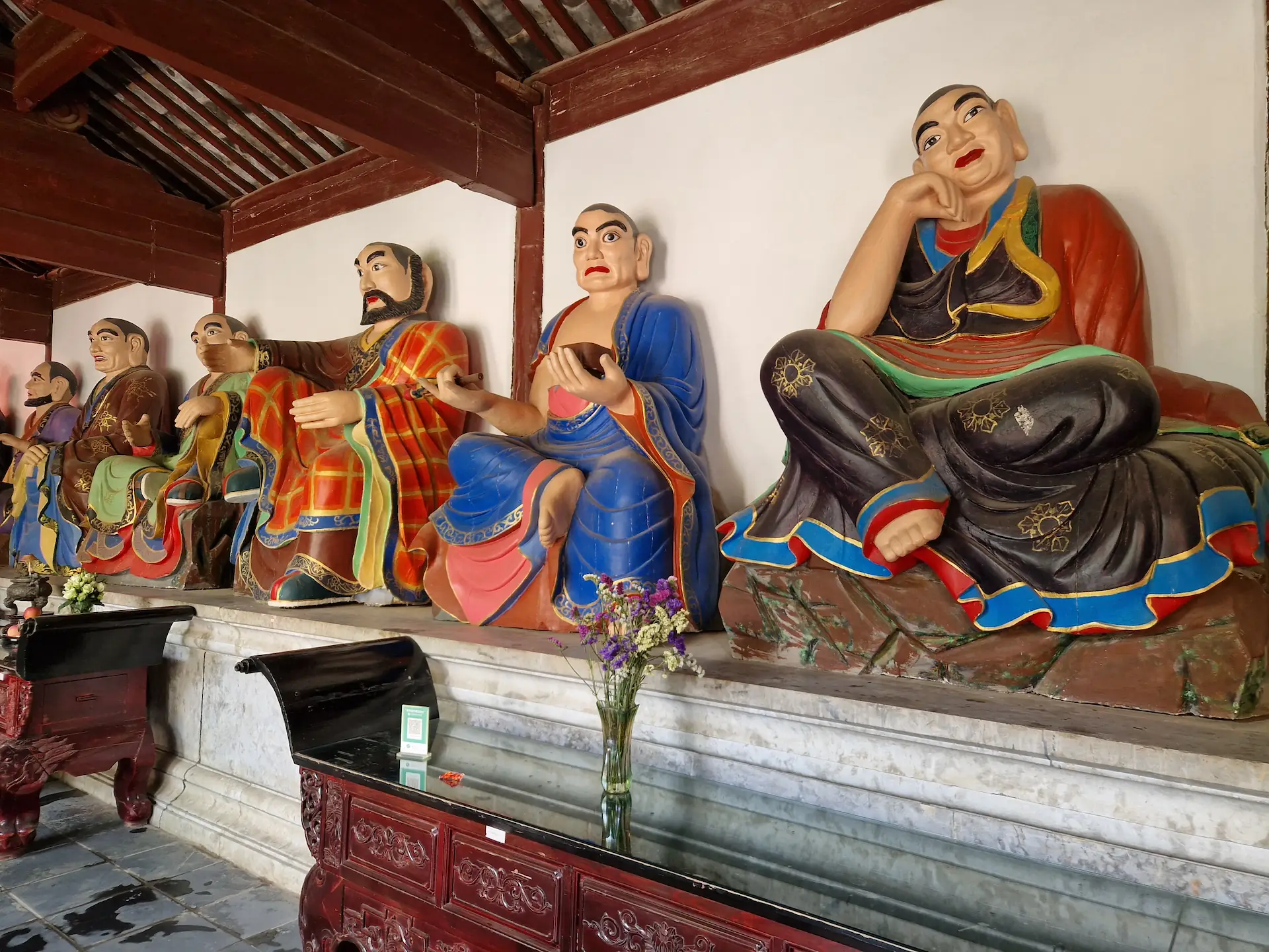 Une série de statues peintes dans un bâtiment du temple.